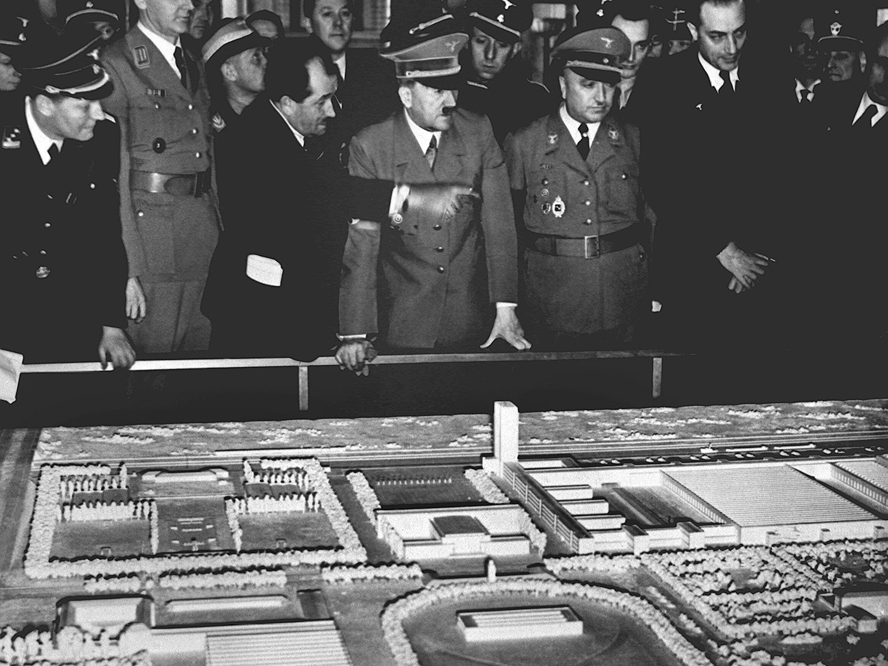 Adolf Hitler kijkt uit over een model van de Volkswagenfabriek en de 'Kraft-durch-Freude-Stadt'.
