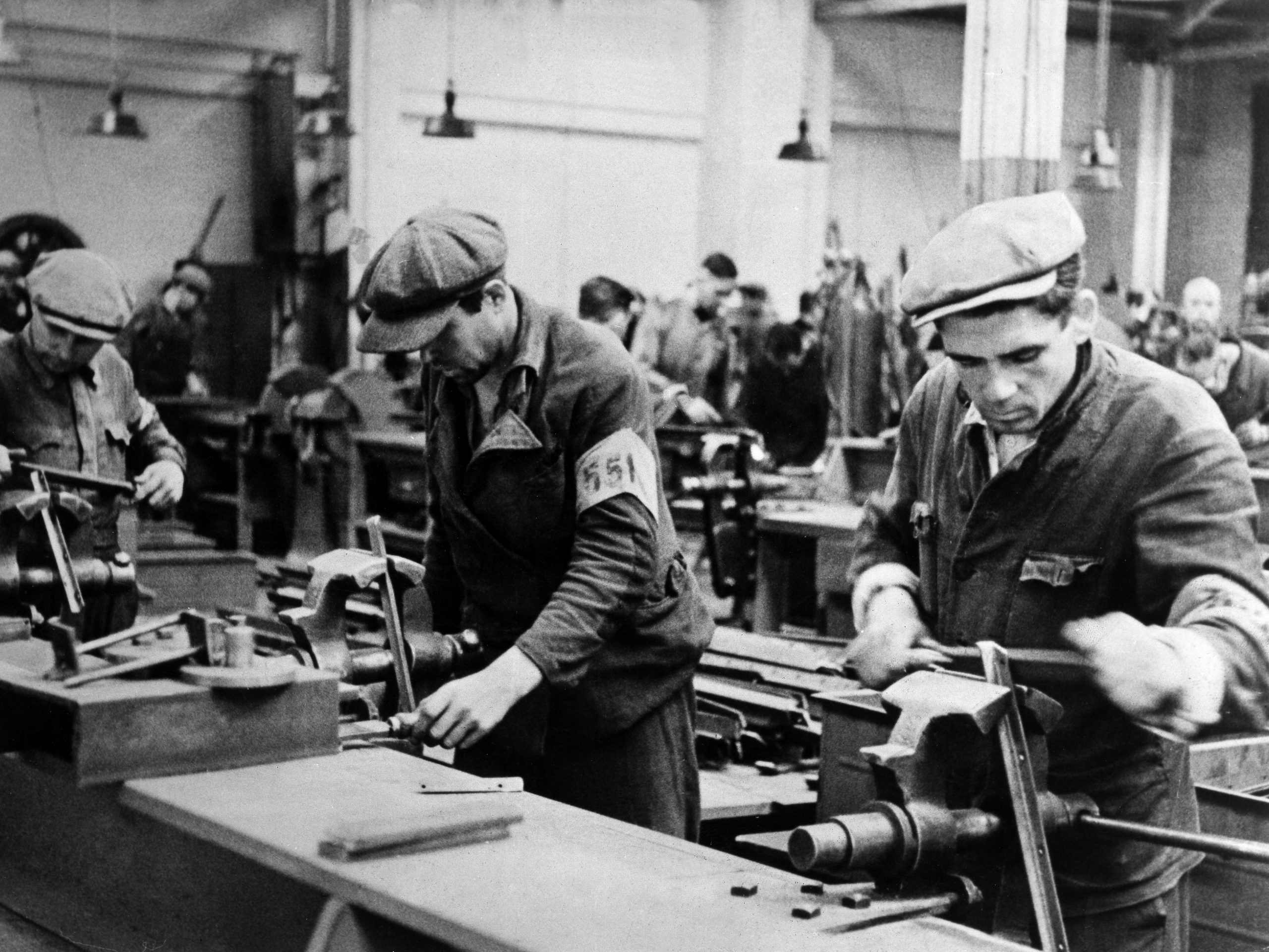 "Ostarbeiter" arbeiders (nazi-term gebruikt om buitenlandse slavenarbeiders uit Oost-Europa aan te duiden) in een wapenfabriek in Zuid-Duitsland met armbanden als merkteken.