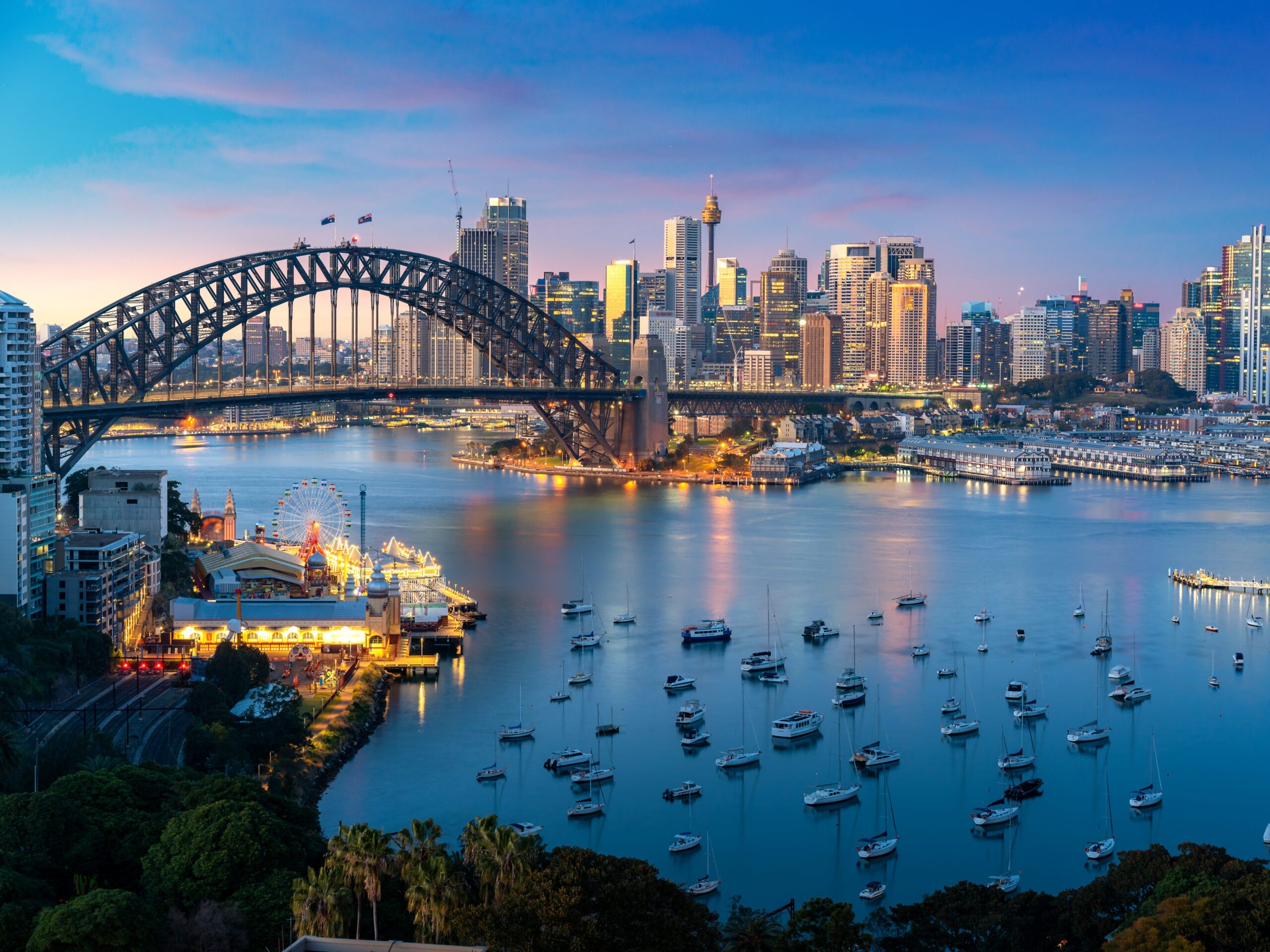 f Sydney, Australia with Harbor Bridge and Sydney skyline during sunset.