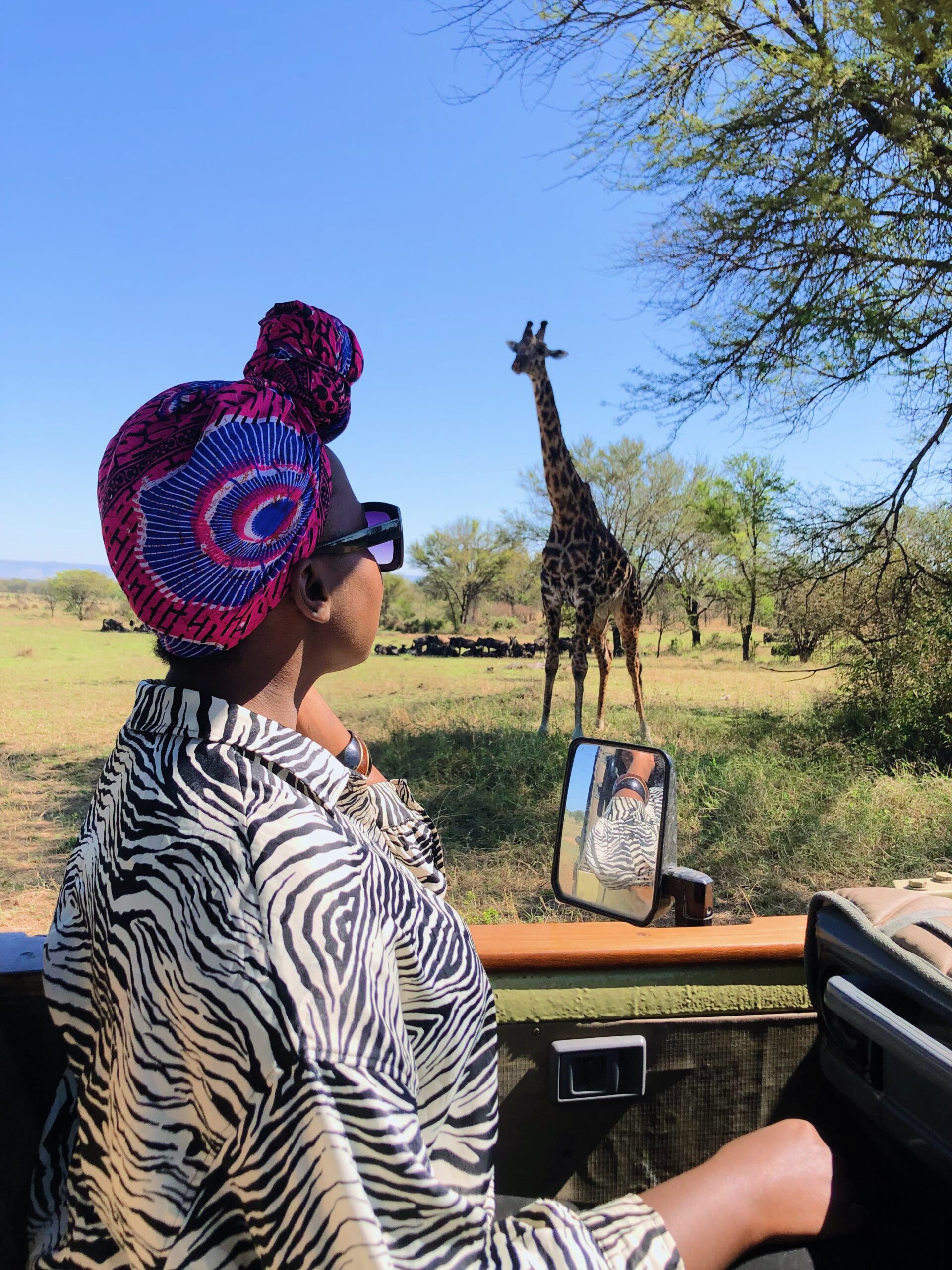 Woman watching a giraffe from a safari vehicle in Serengeti Park
