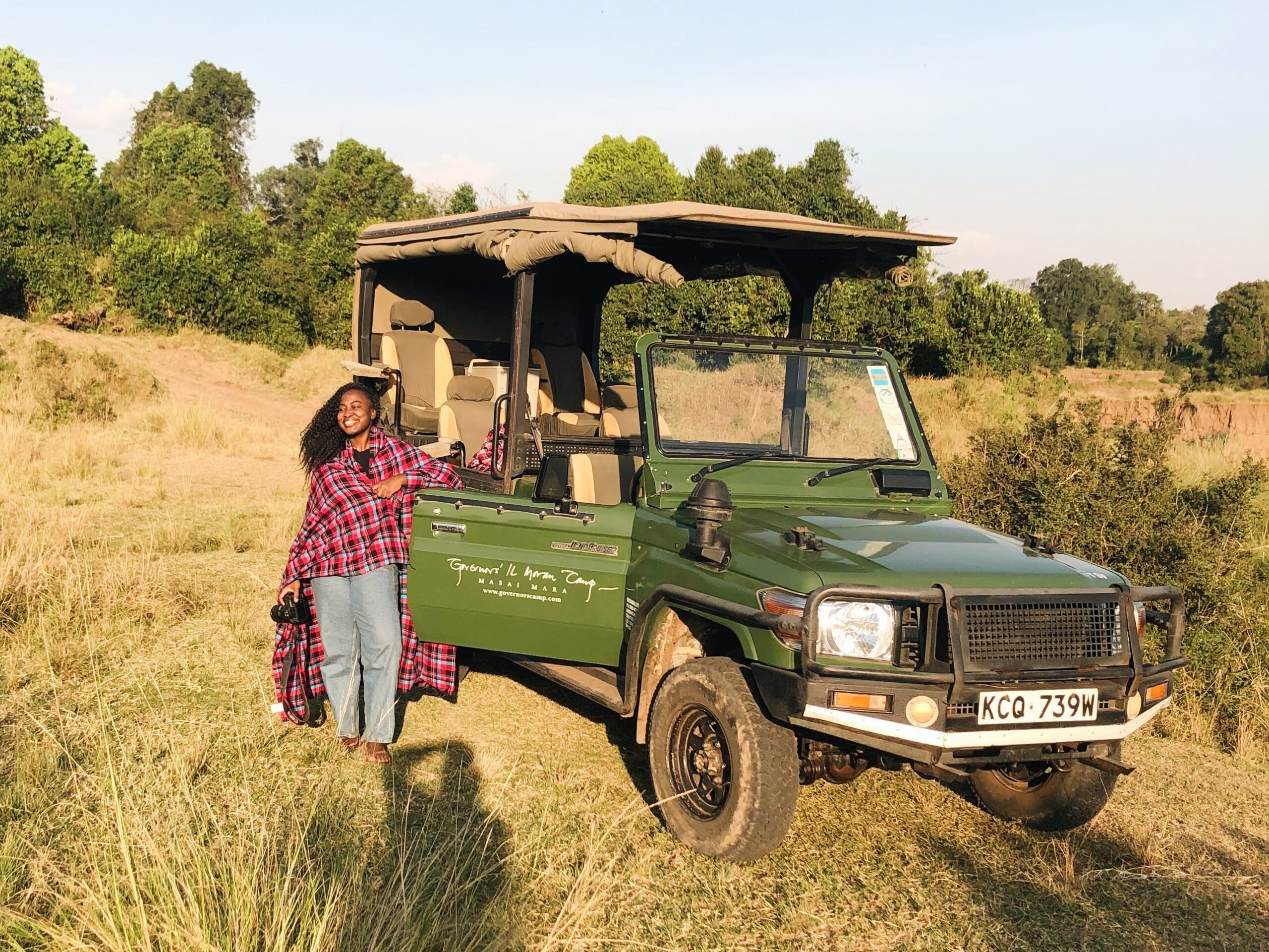 Woman smiling in front of a safari vehicle