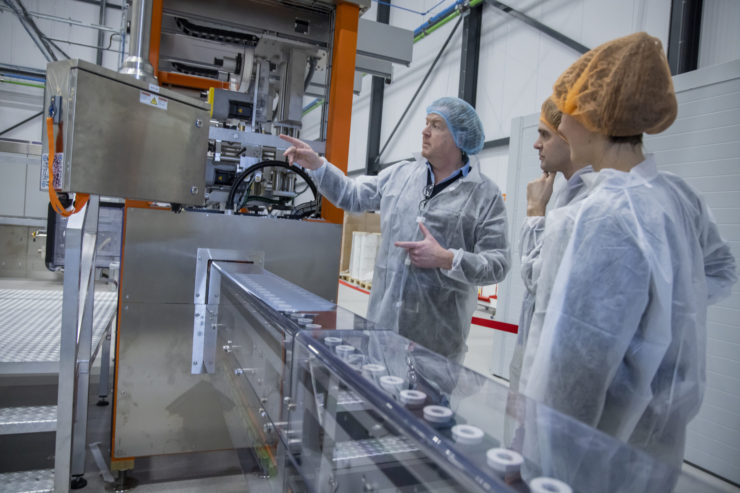 De geurpods zijn op weg naar het stickerapparaat. Euro Caps-ondernemer Nils Clement (links) ziet toe op de dagelijkse productie in de fabriek. Foto: Air Up.