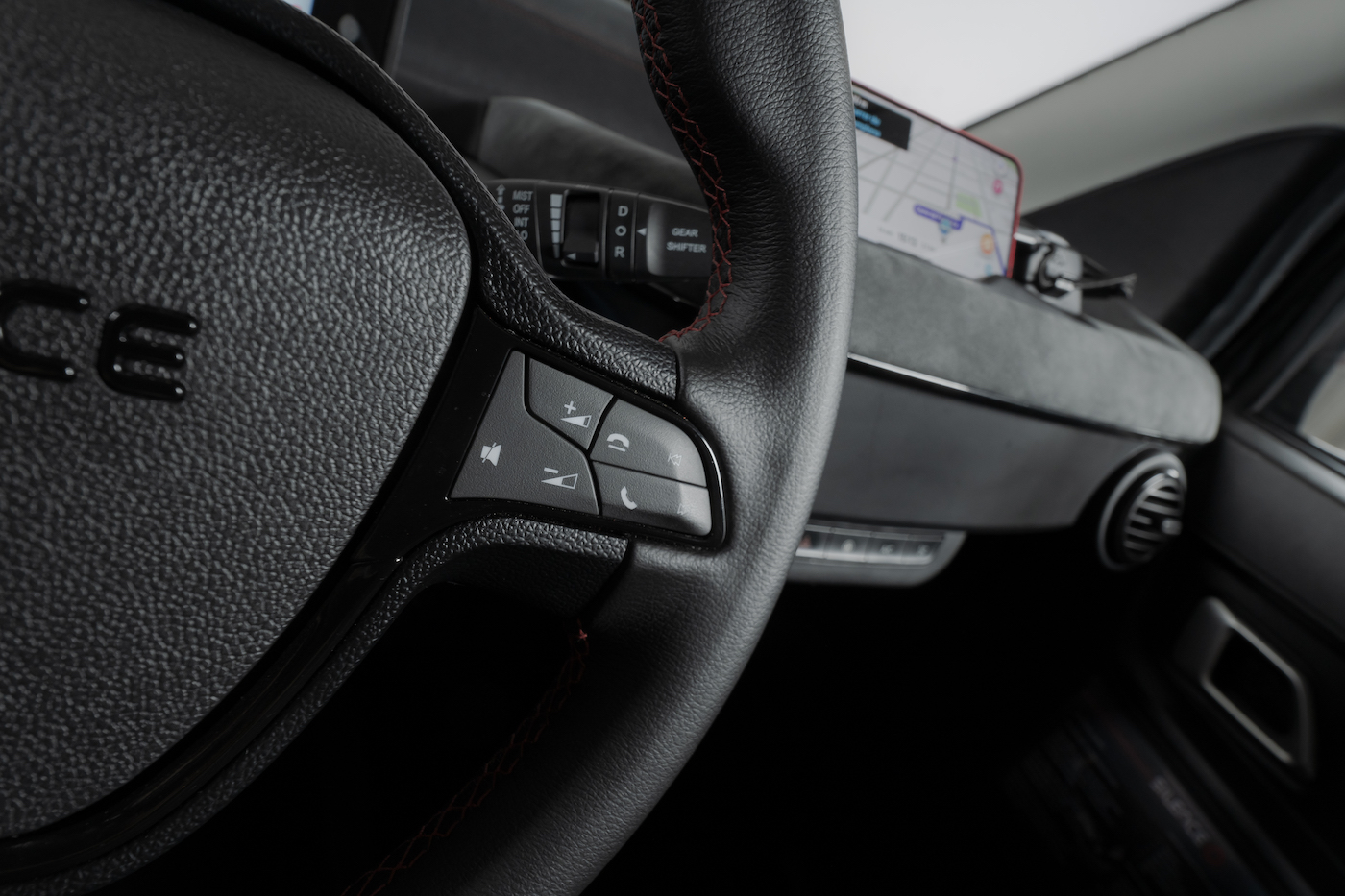 Multifunctioneel stuurwiel, navigatie op de mobiel en een bekleed dashboard.