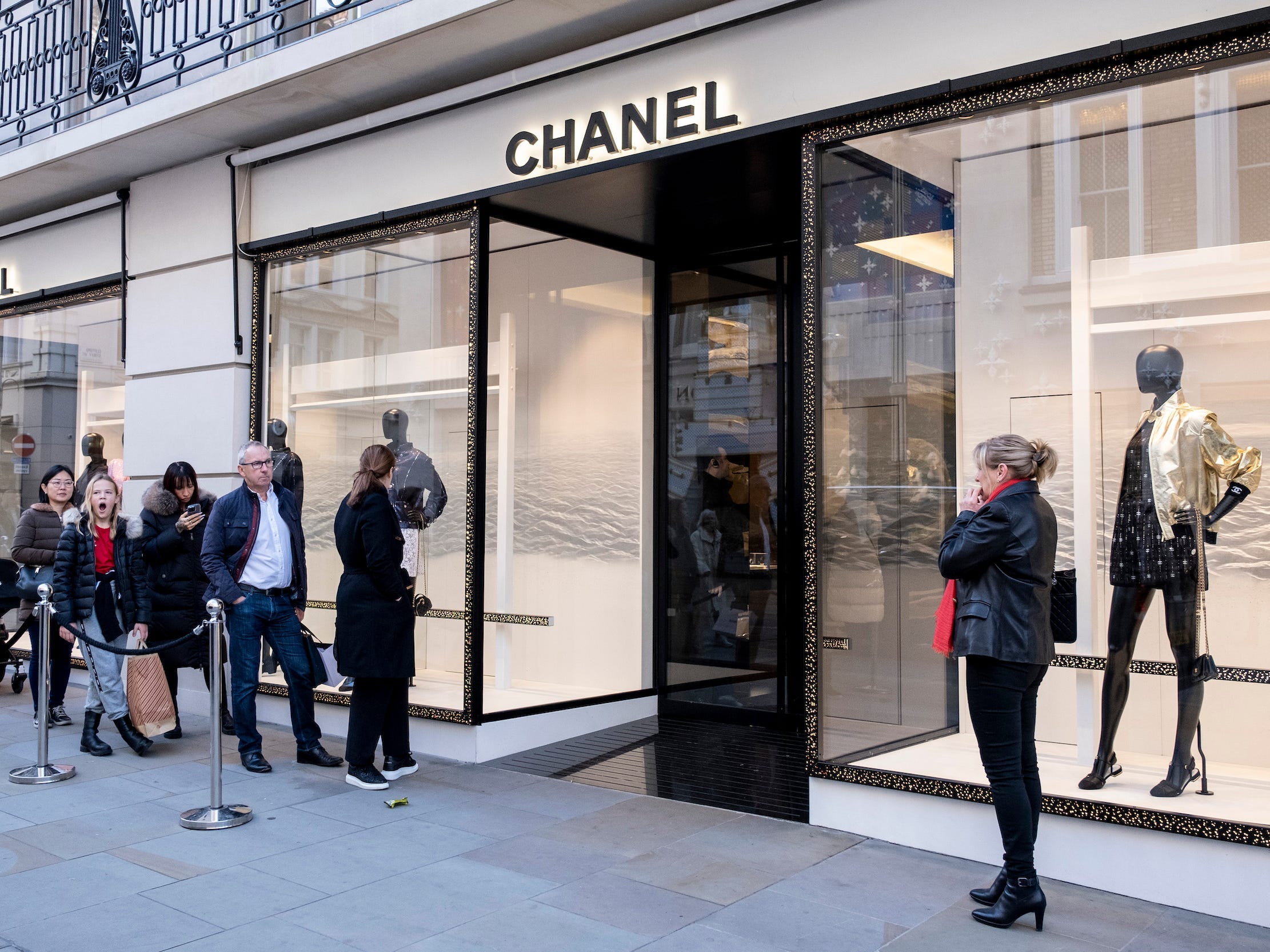 People wait in line outside Chanel store