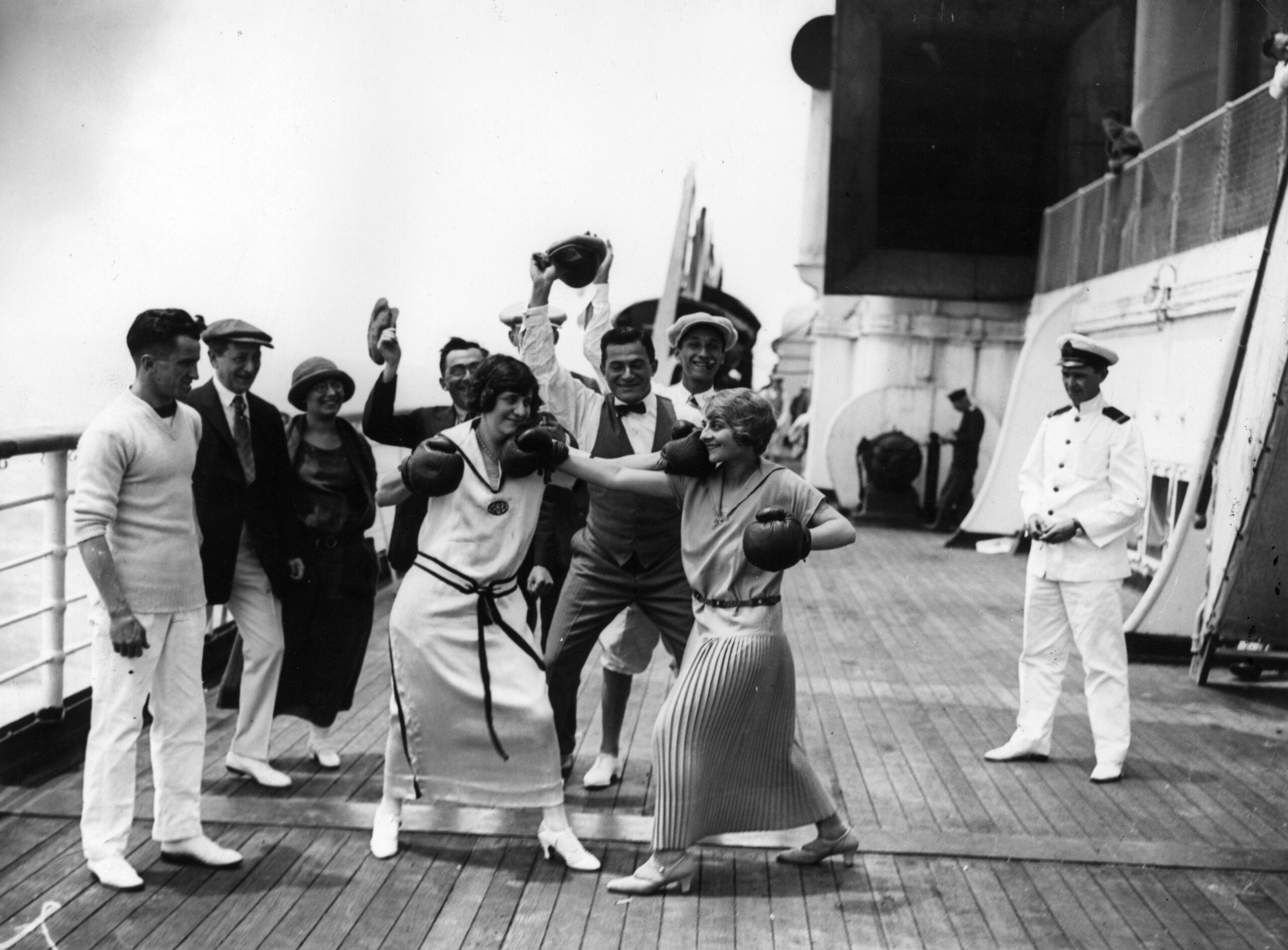 uly 1923: Two women passengers boxing aboard Cunard liner &#39;Berengaria&#39; watched by fellow passengers and an officer.
