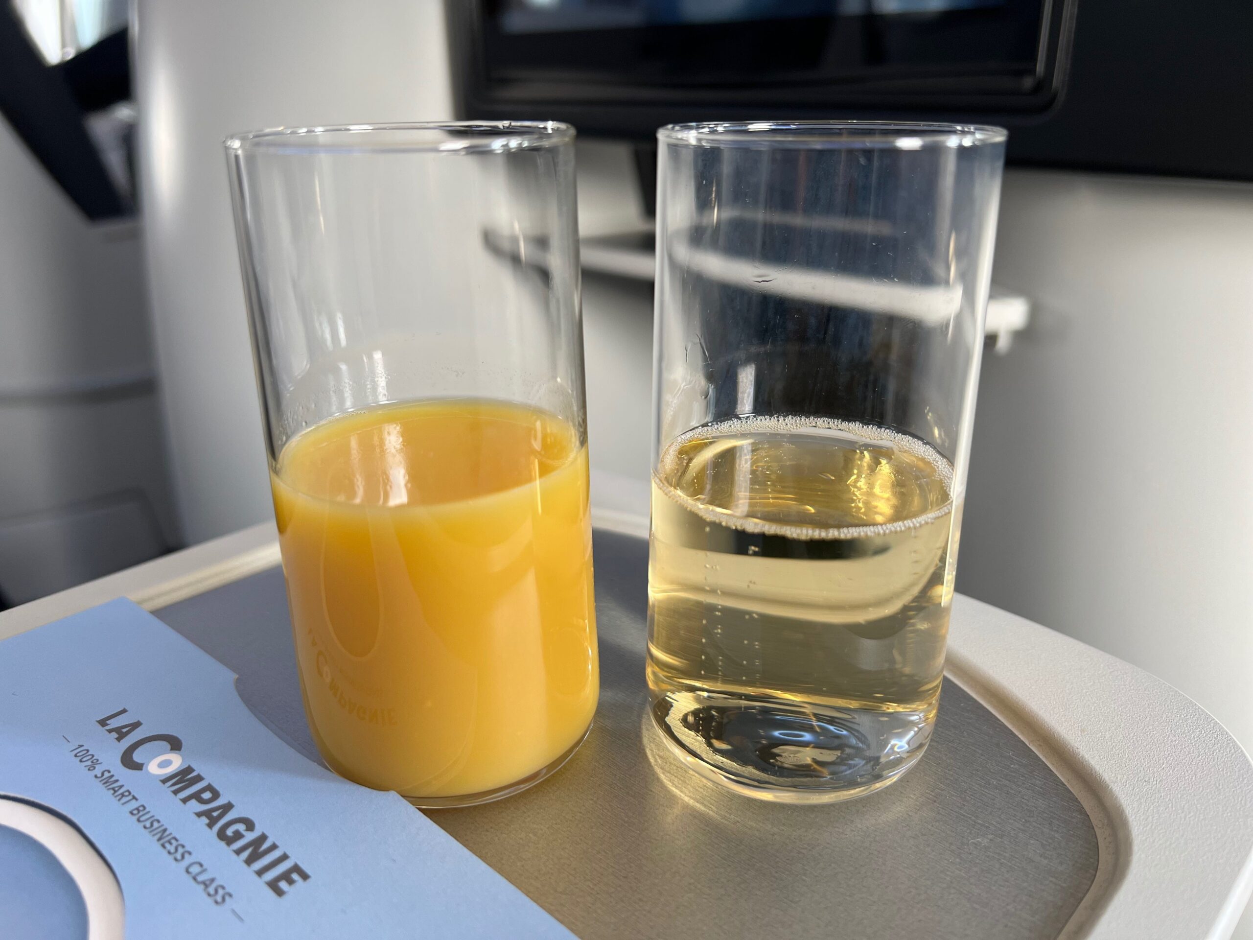 Met La Compagnie all-business class van Parijs naar New York vliegen: mijn sinaasappelsap en champagne in twee glazen.