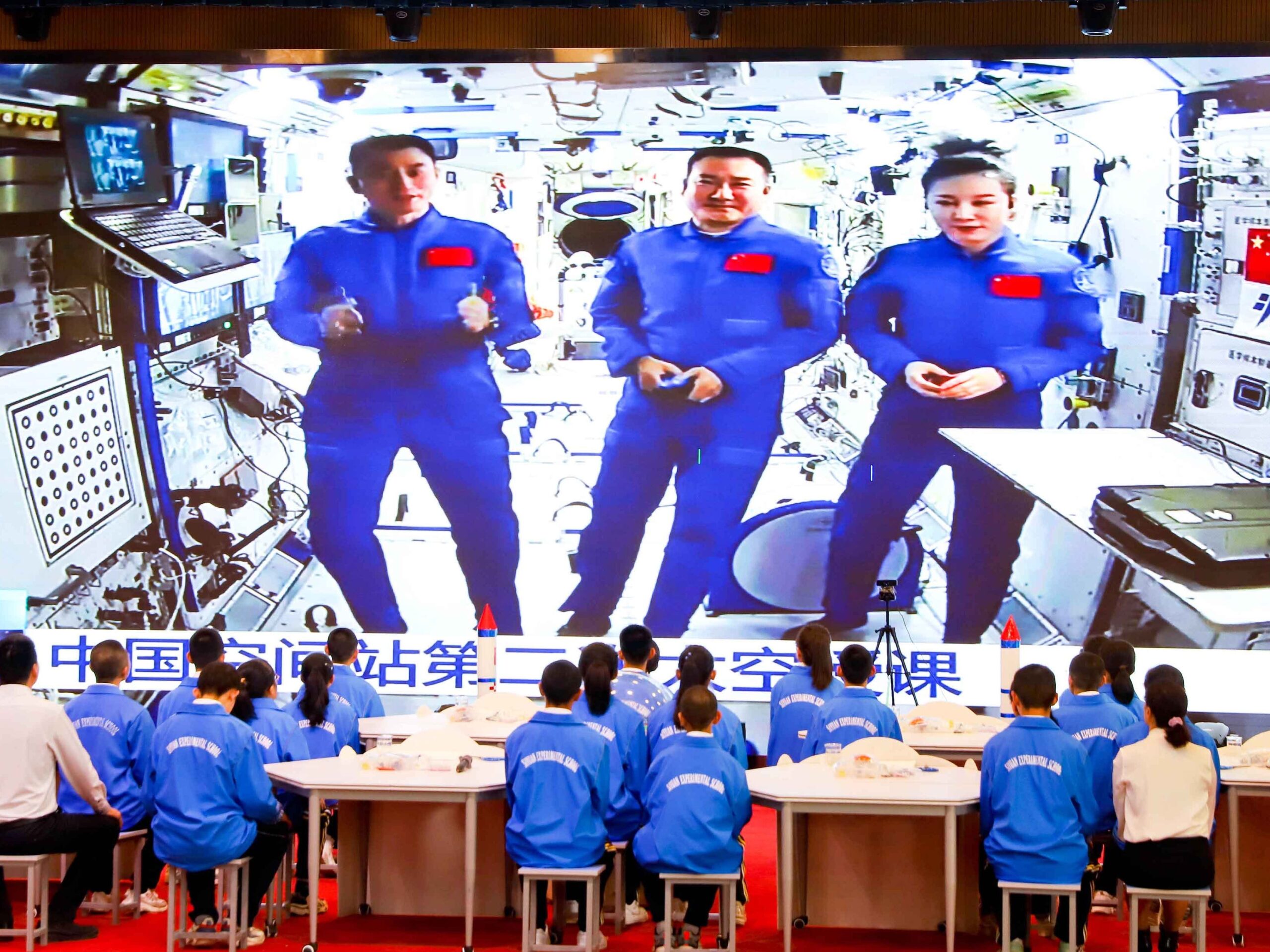 Chinese studenten kijken naar een live-gesprek met drie astronauten in het Tiangong-ruimtestation.