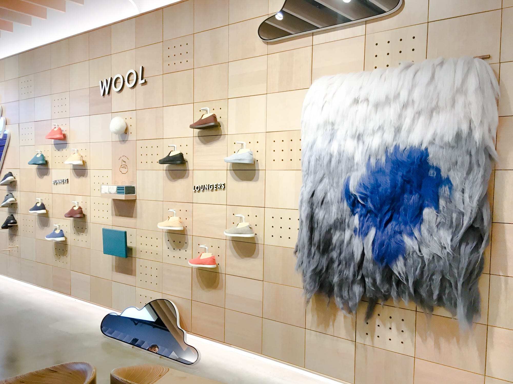 Multiple pairs of sneakers lined up on a wall in Allbirds&#39; first store in Soho, New York City.