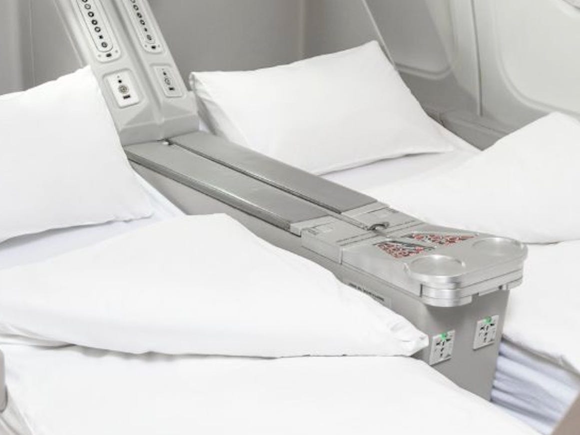 AirX Charters' A340 business class seats in lie-flat mode with white linens.