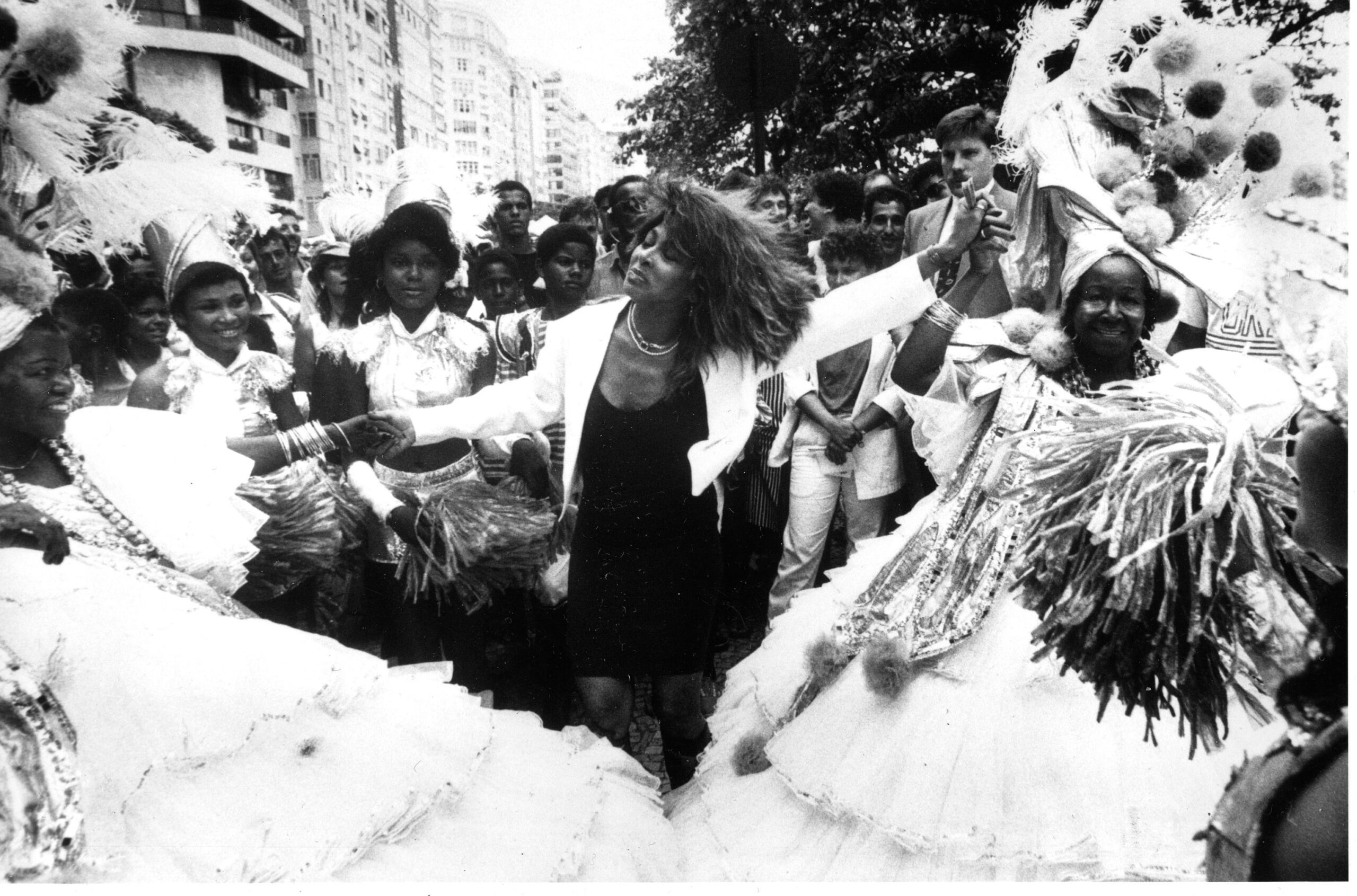 Singer Tina Turner dances the samba with traditional carnival dancers in the streets of Rio de Janeiro, Brazil, December 30, 1987.