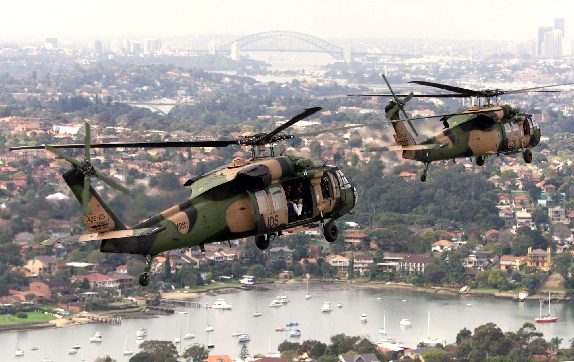 Two Australian Defence Force (ADF) S70A-9 Blackhawk helicopters fly in formation along Sydney&#39;s Parramatta River in 1999.