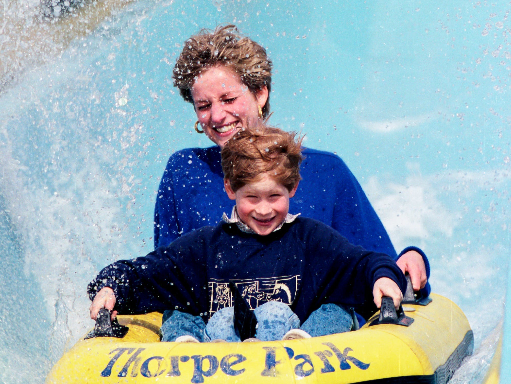 Princess Diana and Prince Harry slide down a water slide.
