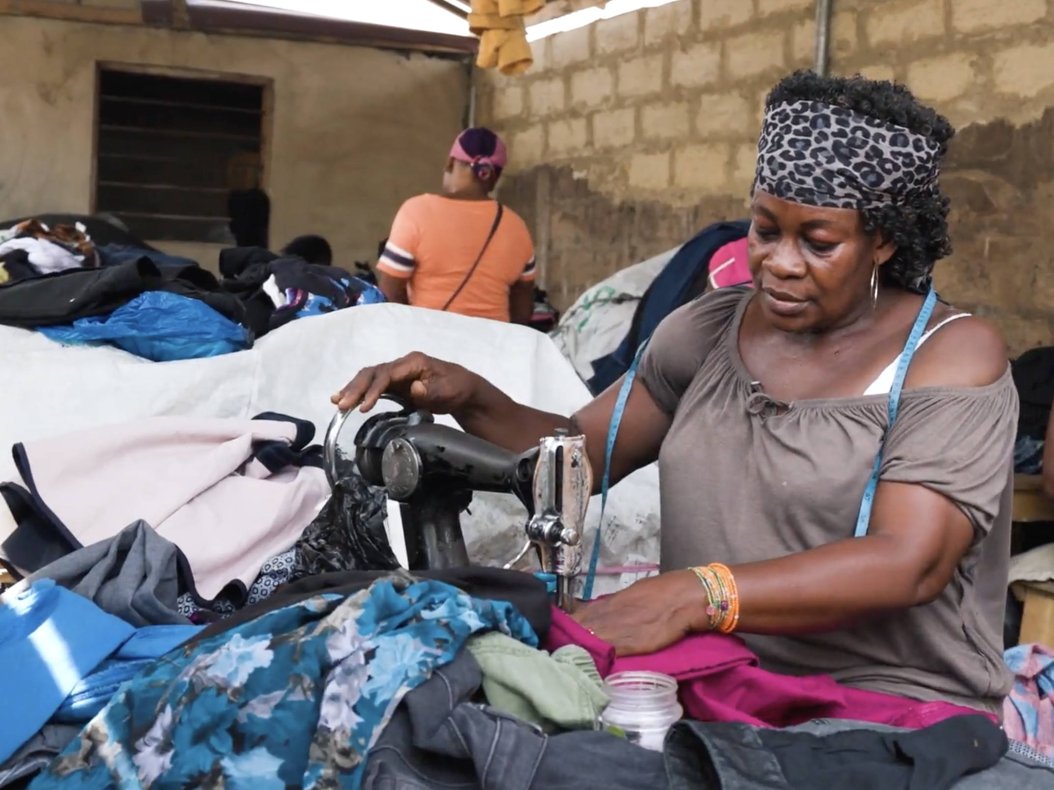 Seamstresses mending ripped clothing in Kantamanto Market