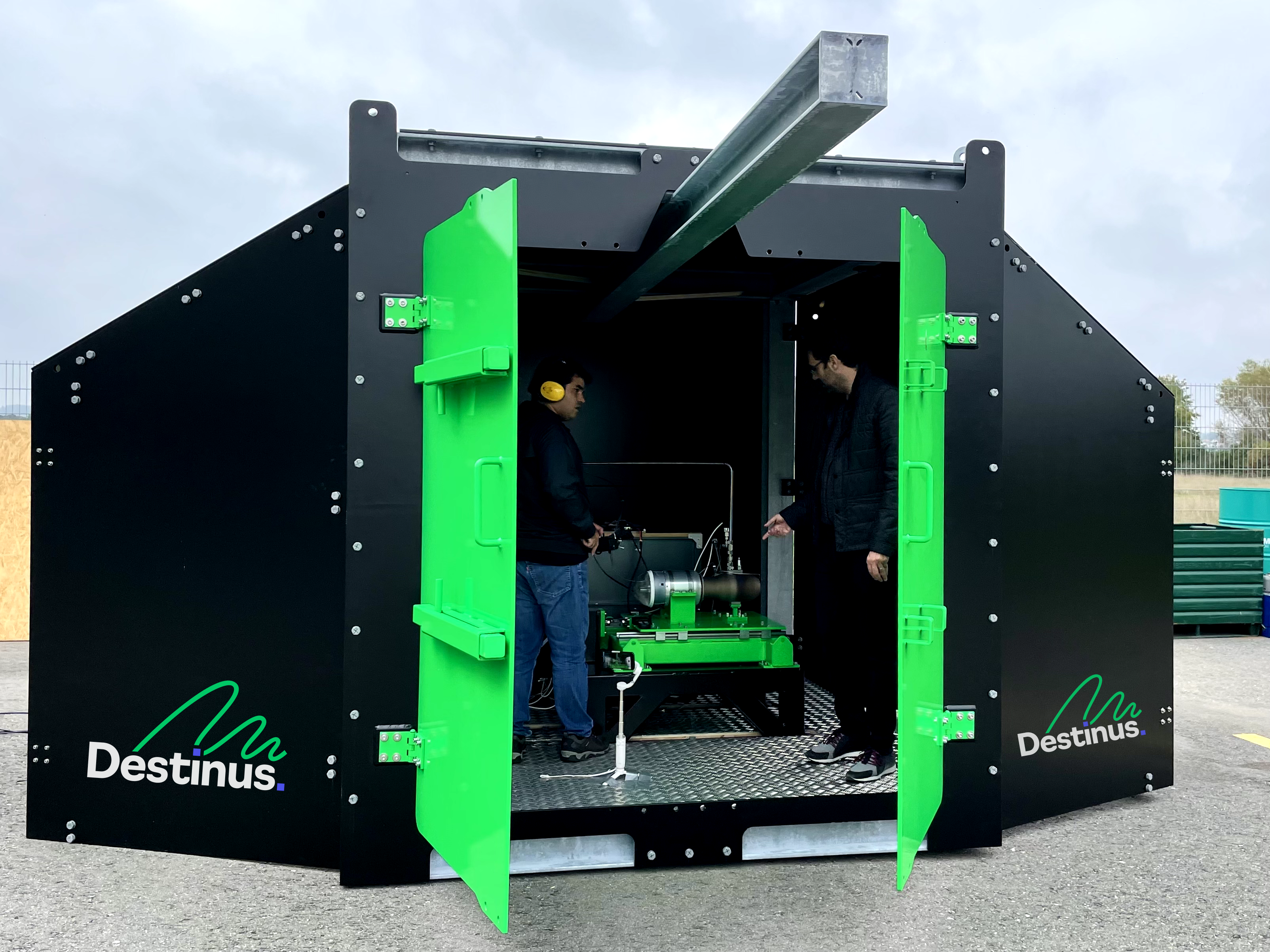 Black and green Destinus hydrogen testing block with employees inside.