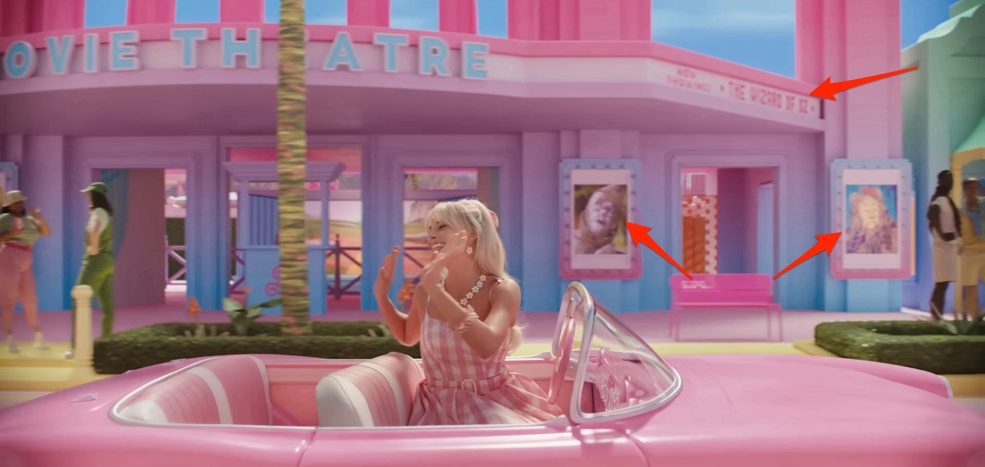 Barbie driving by a movie theater that&#39;s playing &#34;The Wizard of Oz&#34; in &#34;Barbie.&#34;