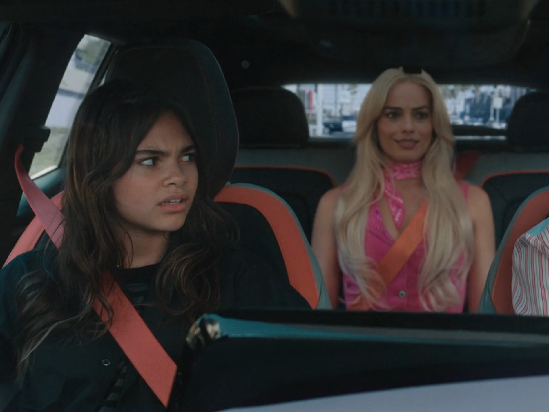 sasha, barbie, and gloria in the car together in barbie. sasha looks disgusted and gloria is cringing