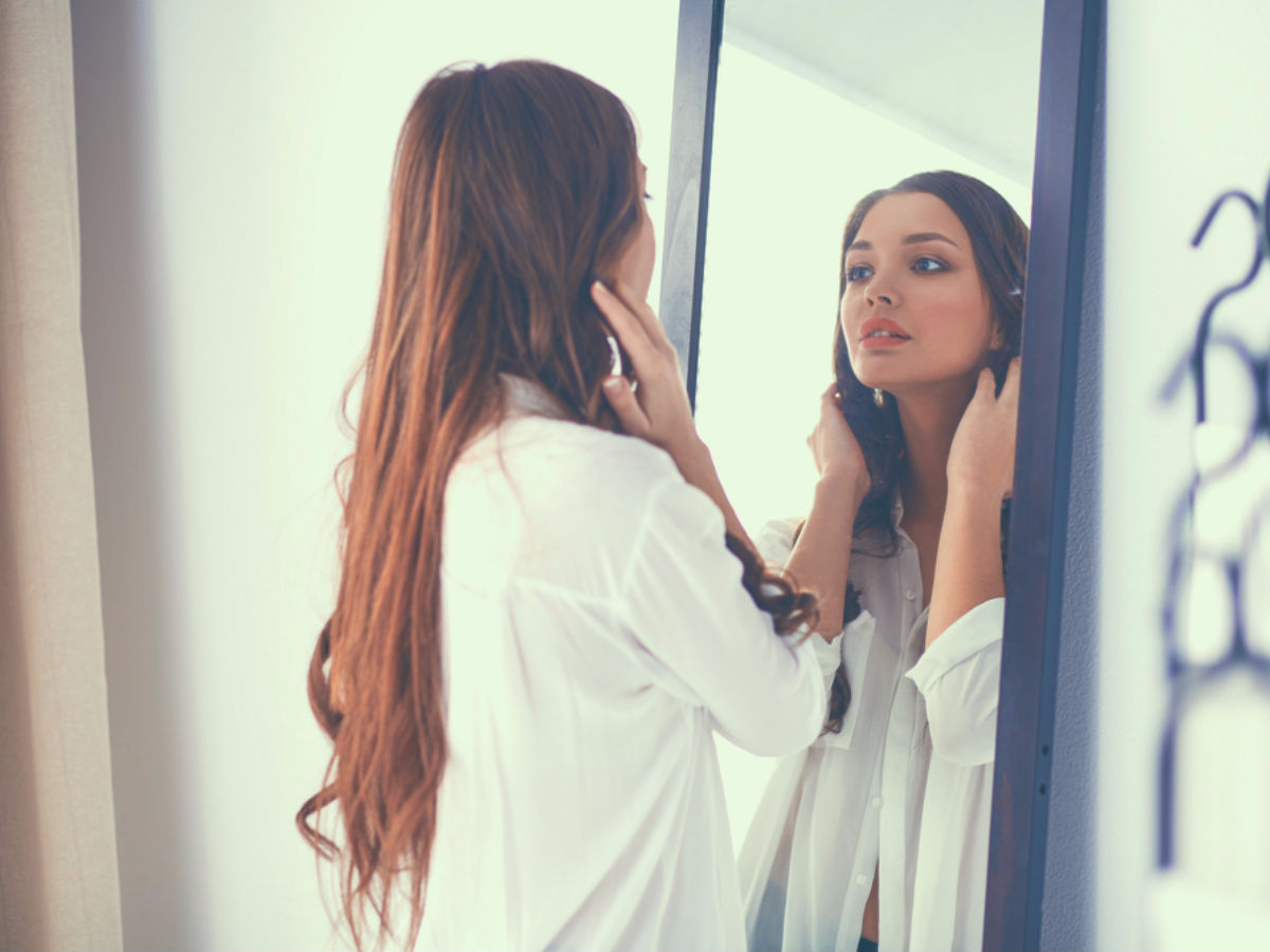 Vrouw kijkend in de spiegel
