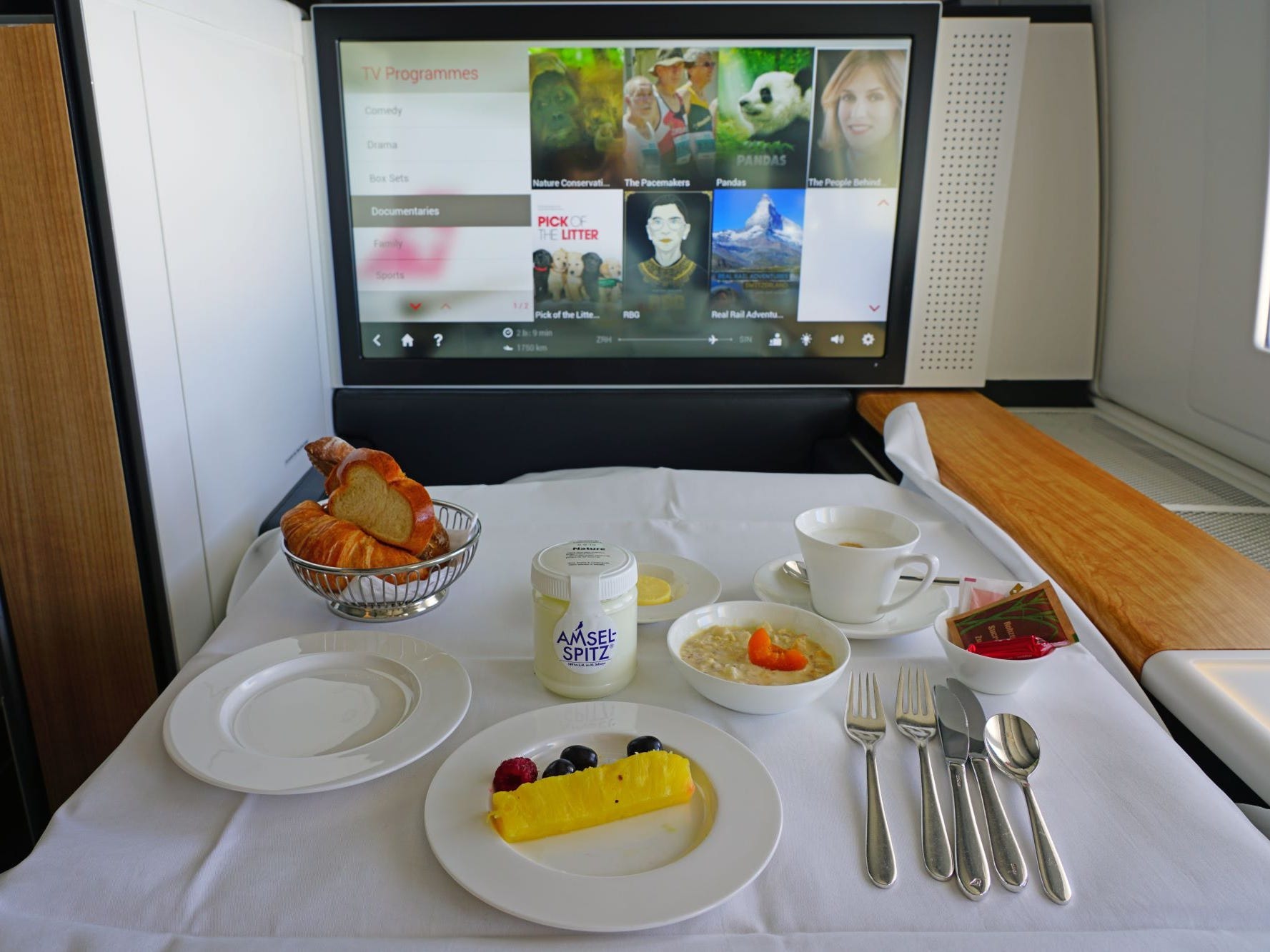 Swiss eerste klas, met een dienbladtafel vol eten en televisie in zicht.