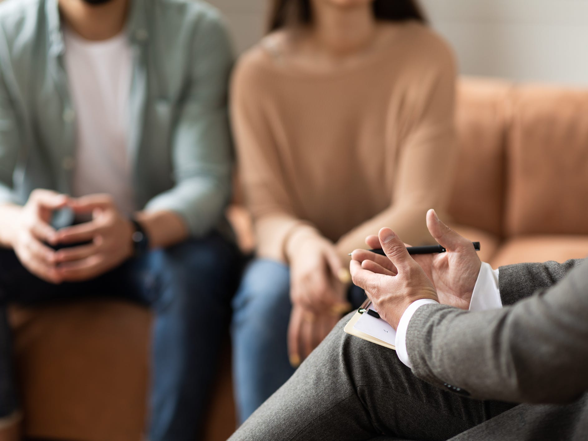 Couple sitting on couch talking to therapist