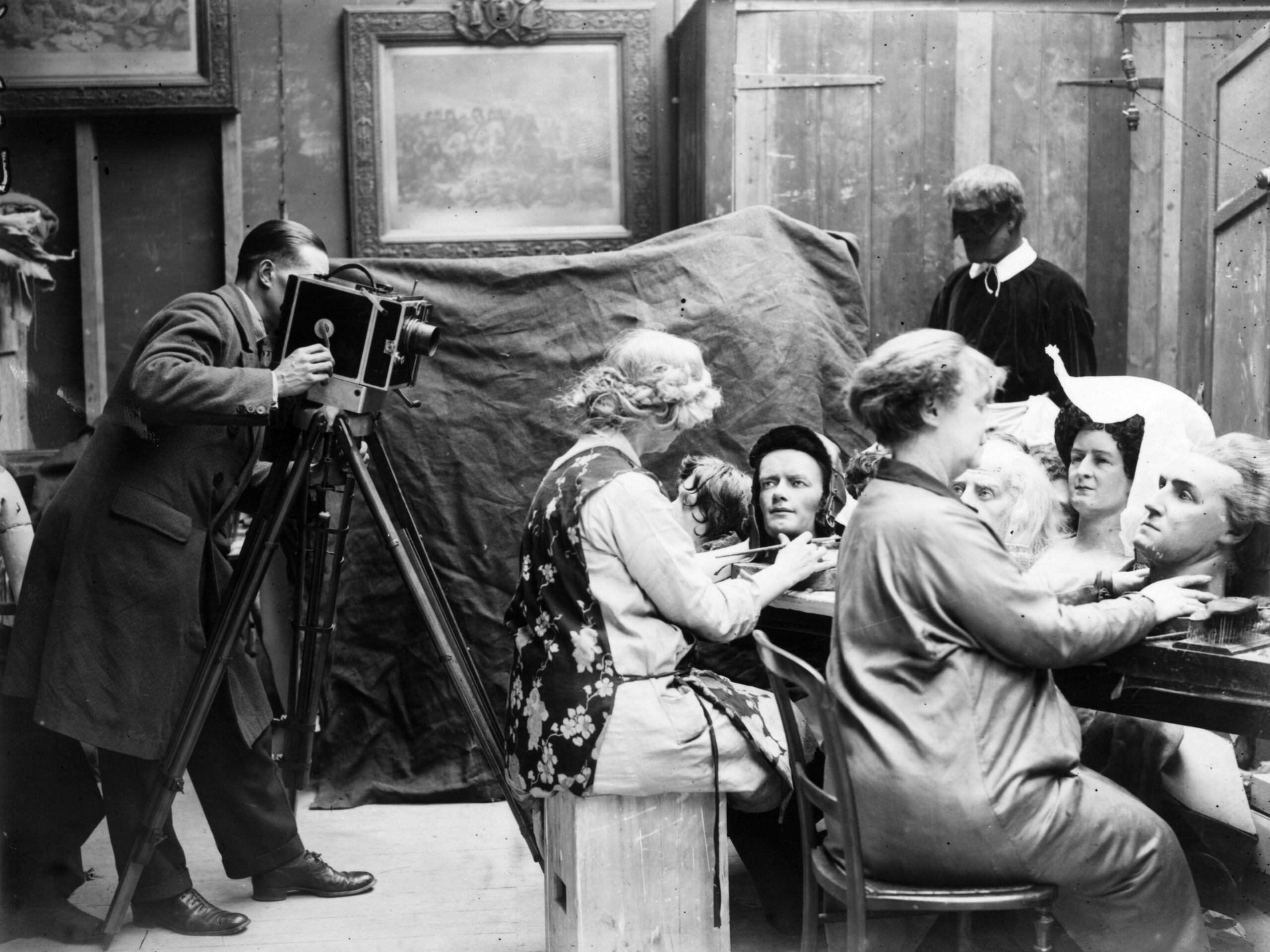 20th March 1928: A cameraman films a couple of women as they craft waxwork heads for a new exhibition at Madame Tussaud&#39;s museum in London. (
