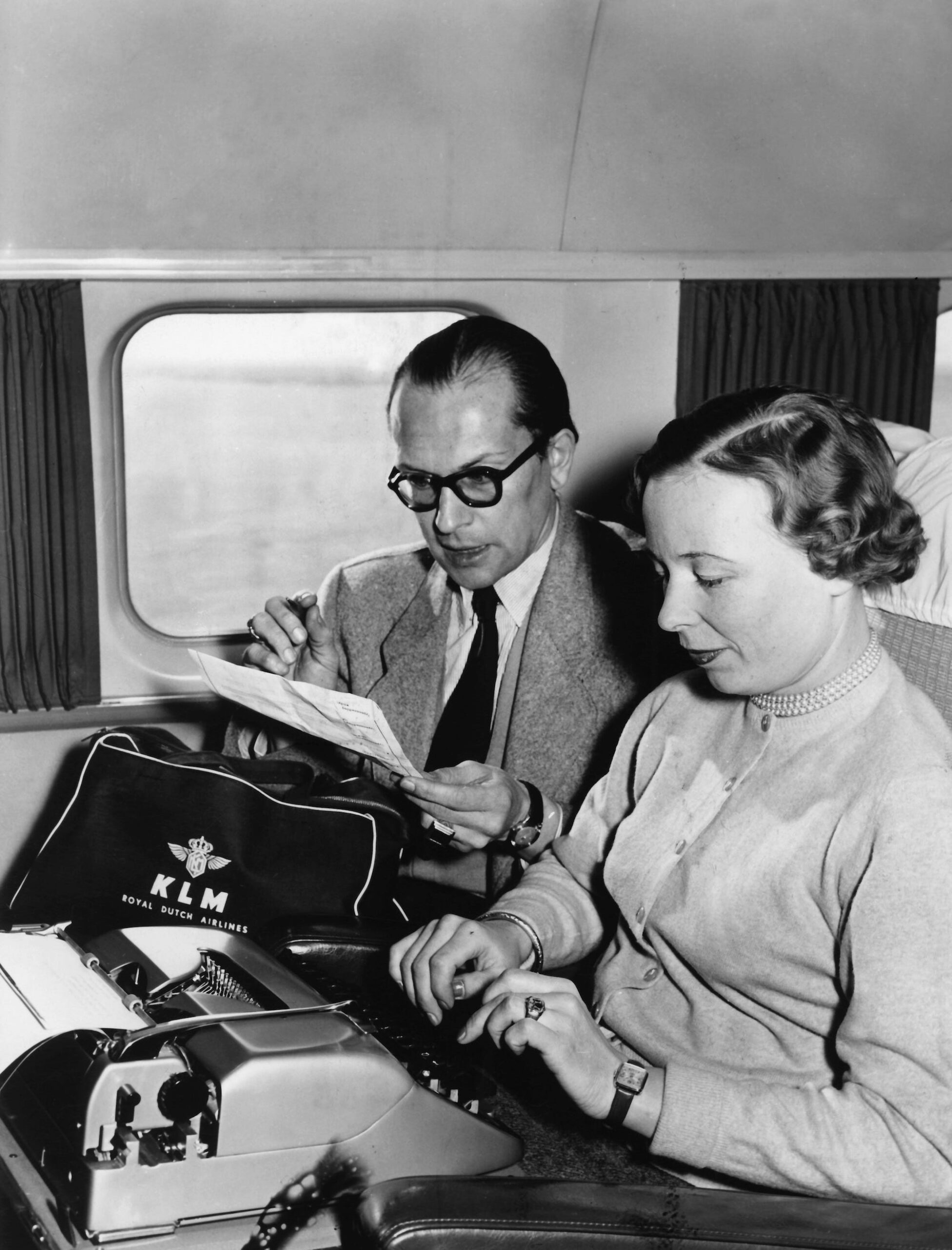 A secretary typing on a typewriter on a plane in 1955