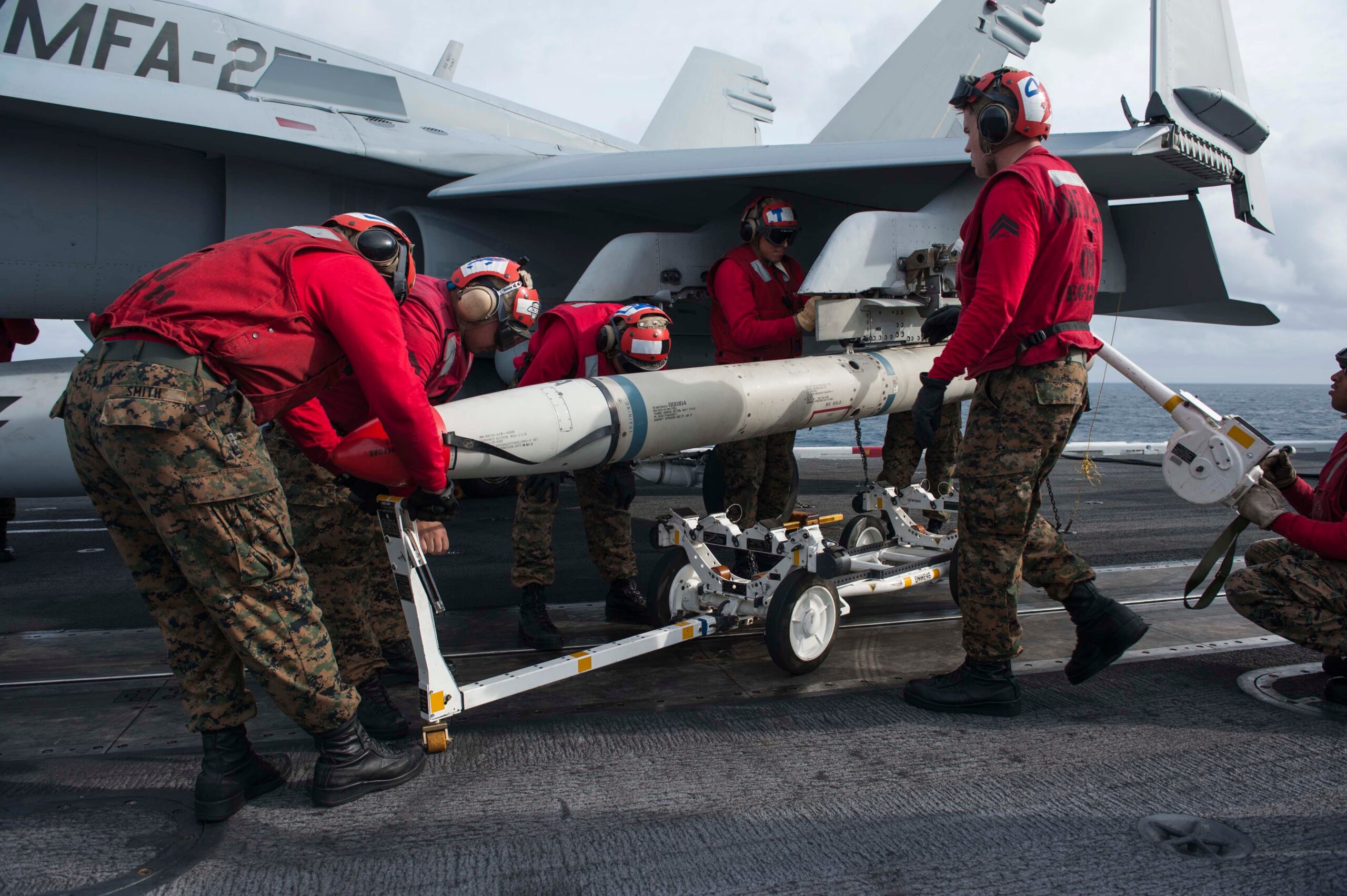 Amerikaanse mariniers verwijderen een HARM-raket van een F/A-18C Hornet op het vliegdekschip USS Theodore Roosevelt.