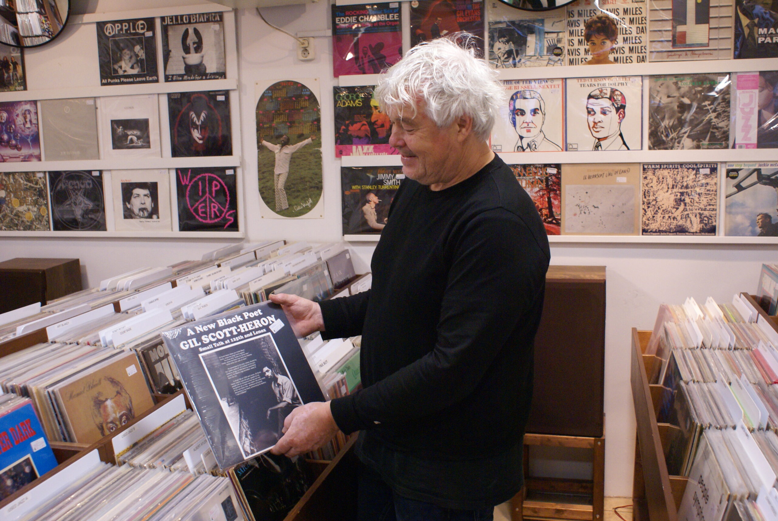 Dick van Dijk op de tweedehandsafdeling van zijn winkel Concerto, met een plaat van soulartiest Gil Scott-Heron in de hand.