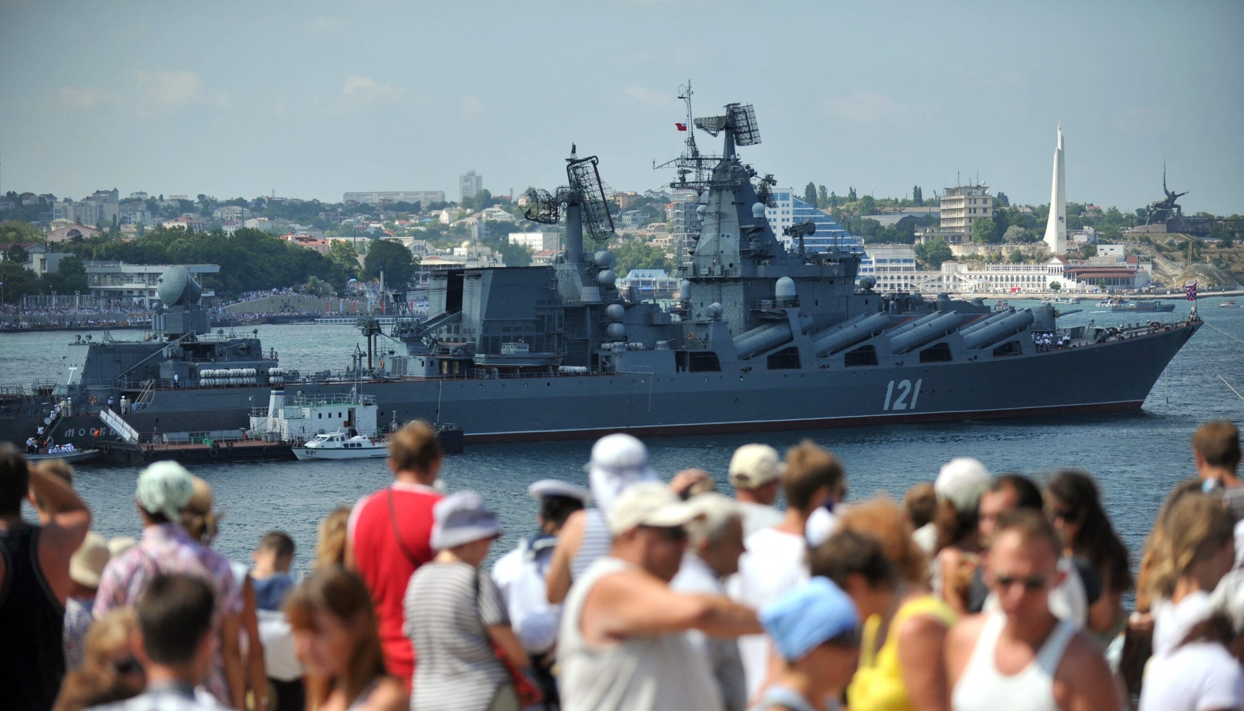 the Moskva guided missile cruiser behind a crowd of people