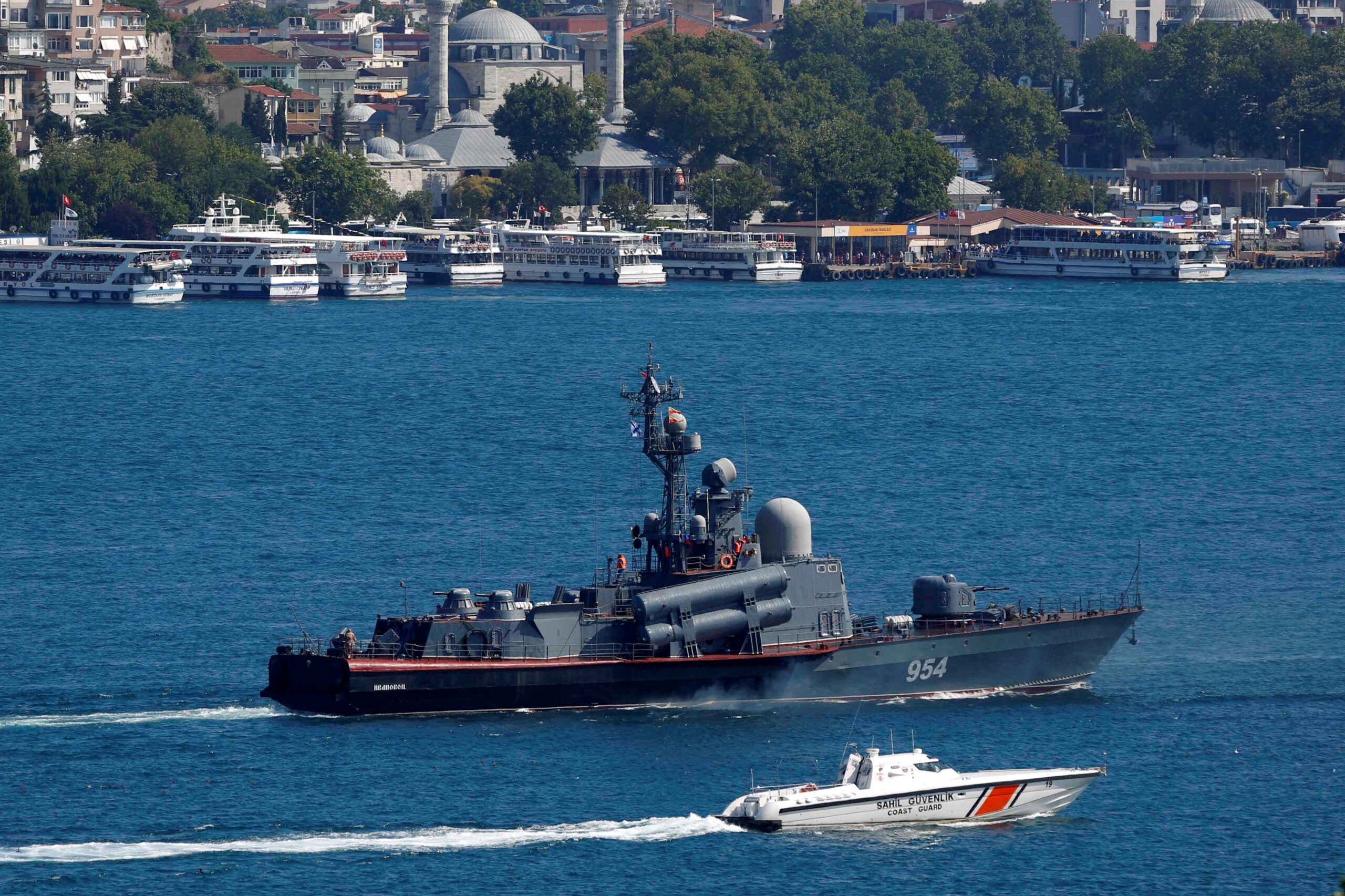 A Russian navy warship is escorted by a smaller Turkish navy boat