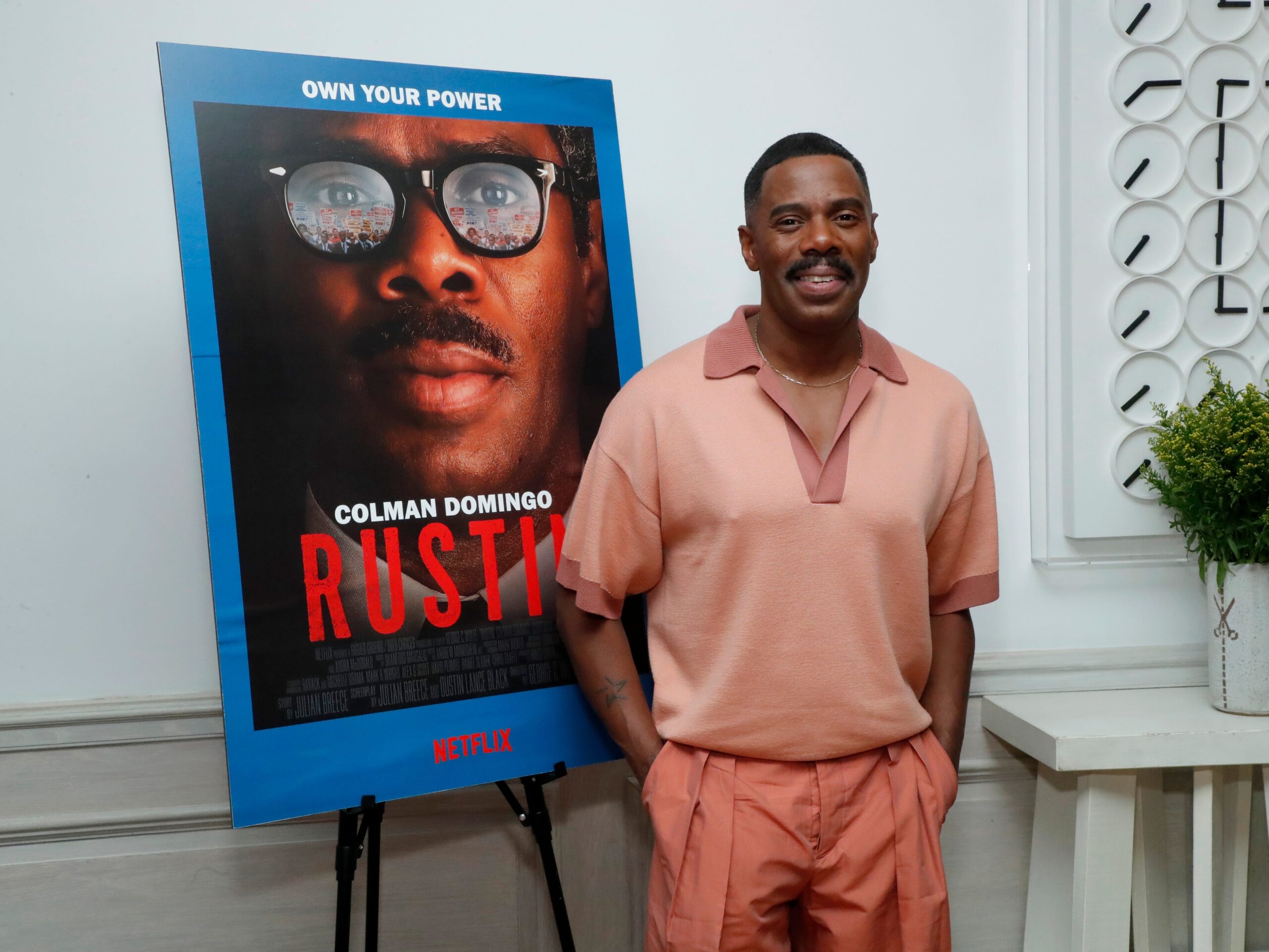 Oscar nominee Colman Domingo in front of a poster for the film Rustin.