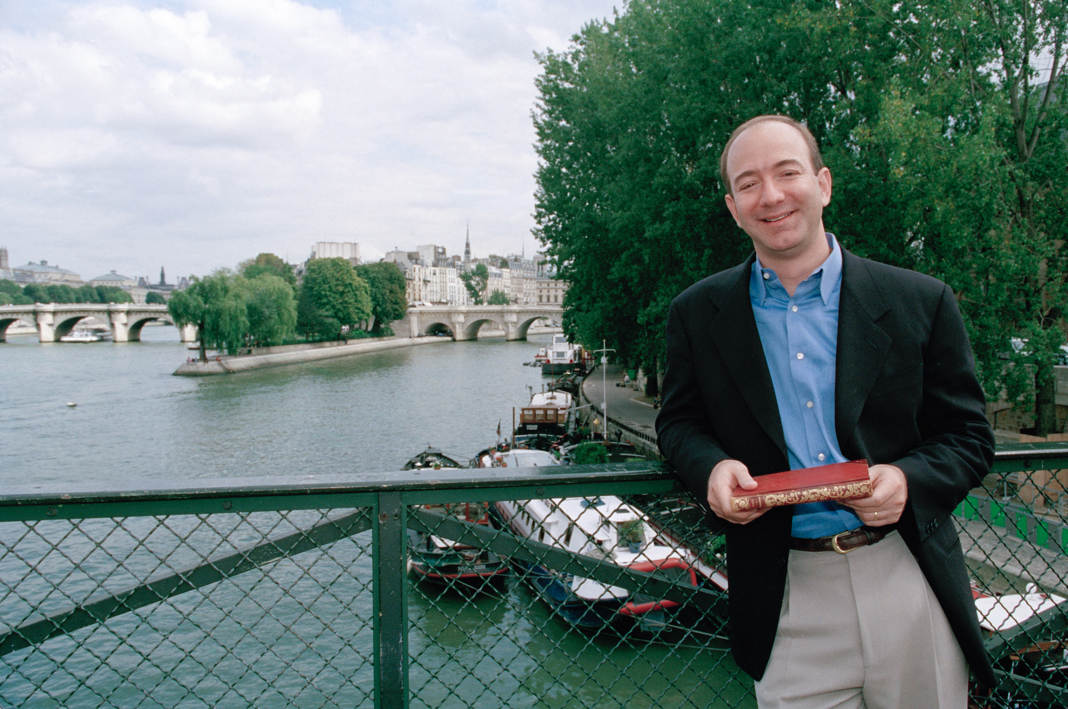 Jeff Bezos young wearing a light blue shirt and beige trousers 