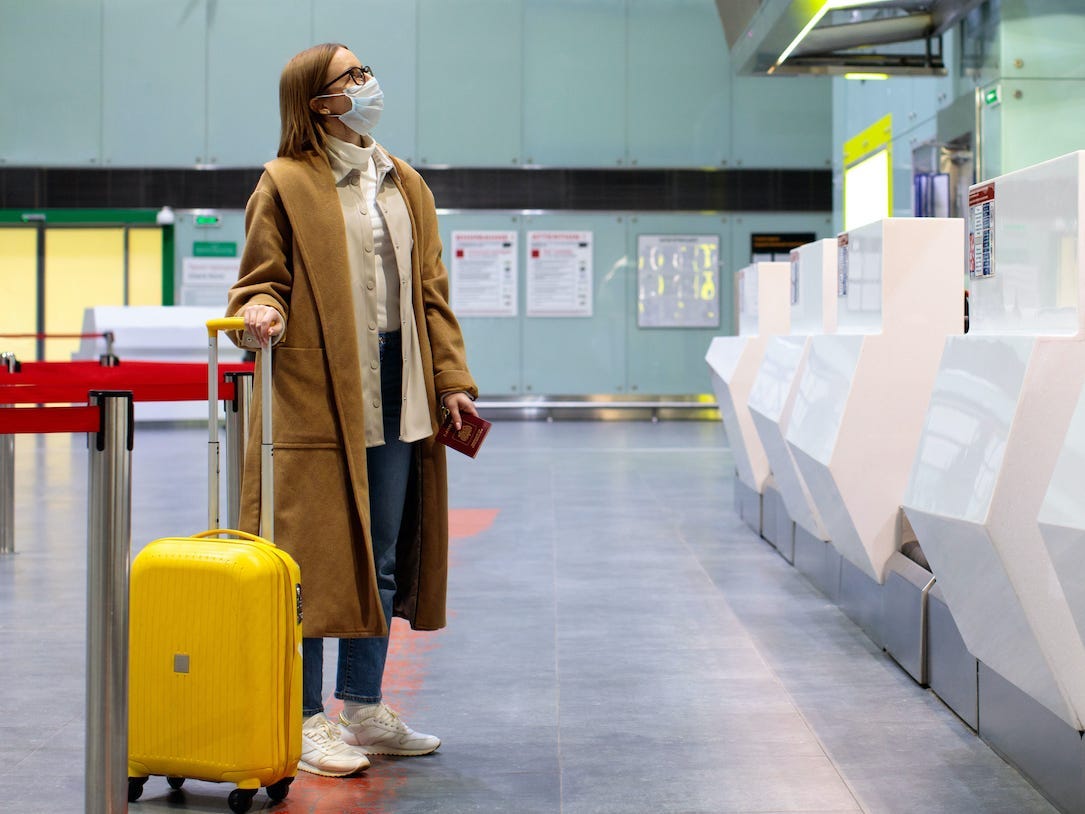Een vrouw draagt een jas op een vliegveld.