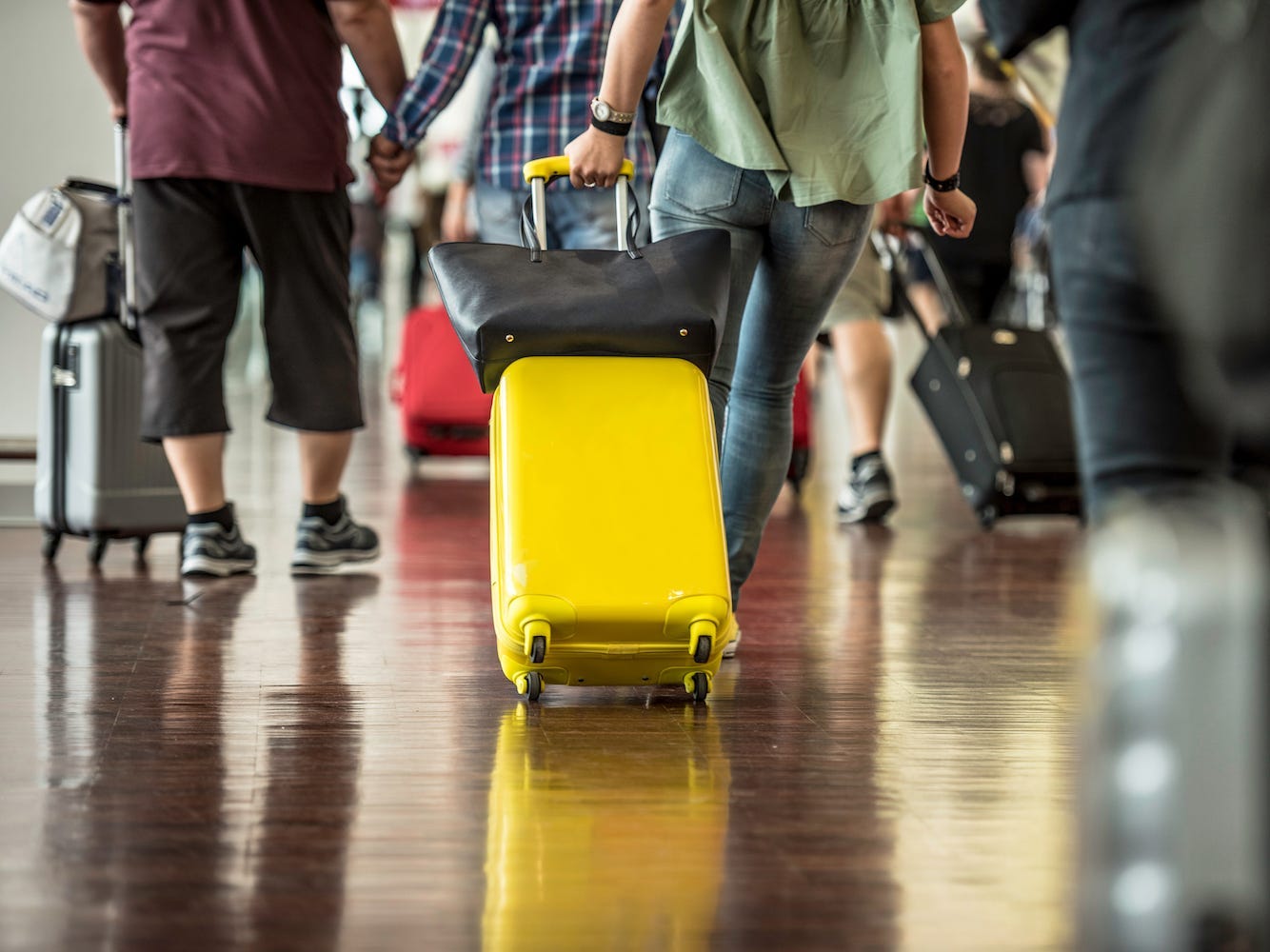 A person pulls two bags through an airport.