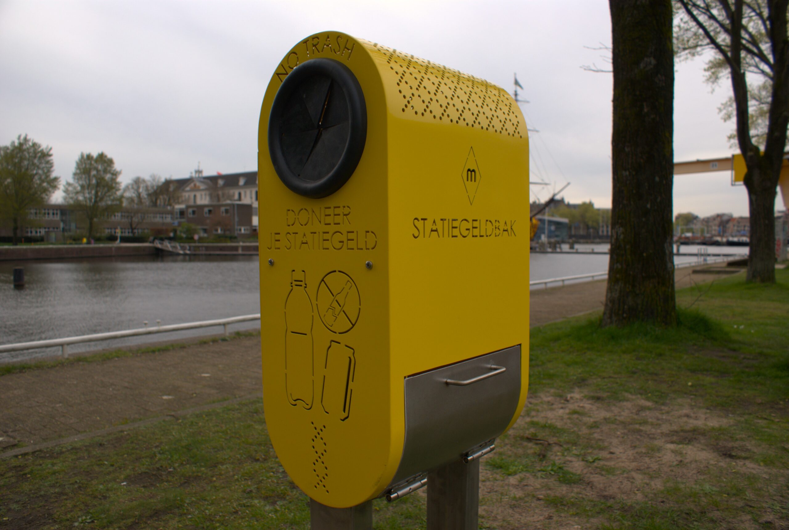 Een van de statiegeldbakken van Art for Impact aan het Amsterdamse marineterrein. Aan de rechterzijde kunnen geïnteresseerden de flesjes en blikjes eruit halen.