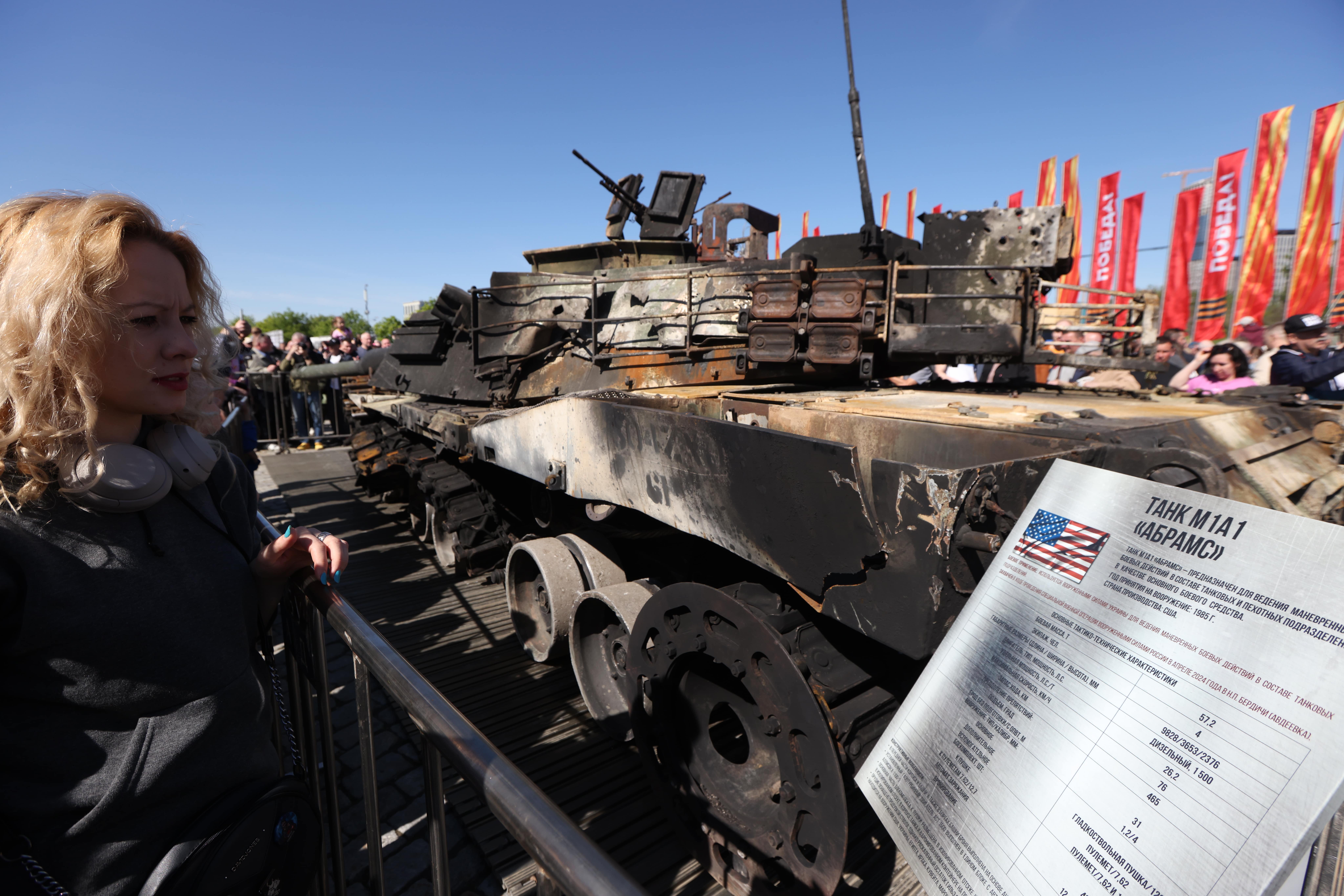 A woman reads a placard with information on the Abrams.