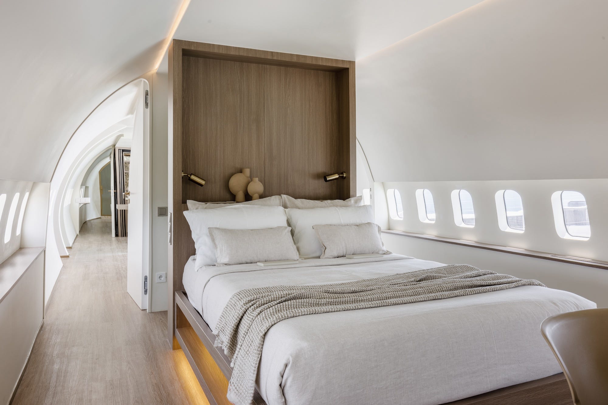 De slaapkamer in het vliegtuig. Het bed heeft een ingebouwd, houten hoofdeinde.