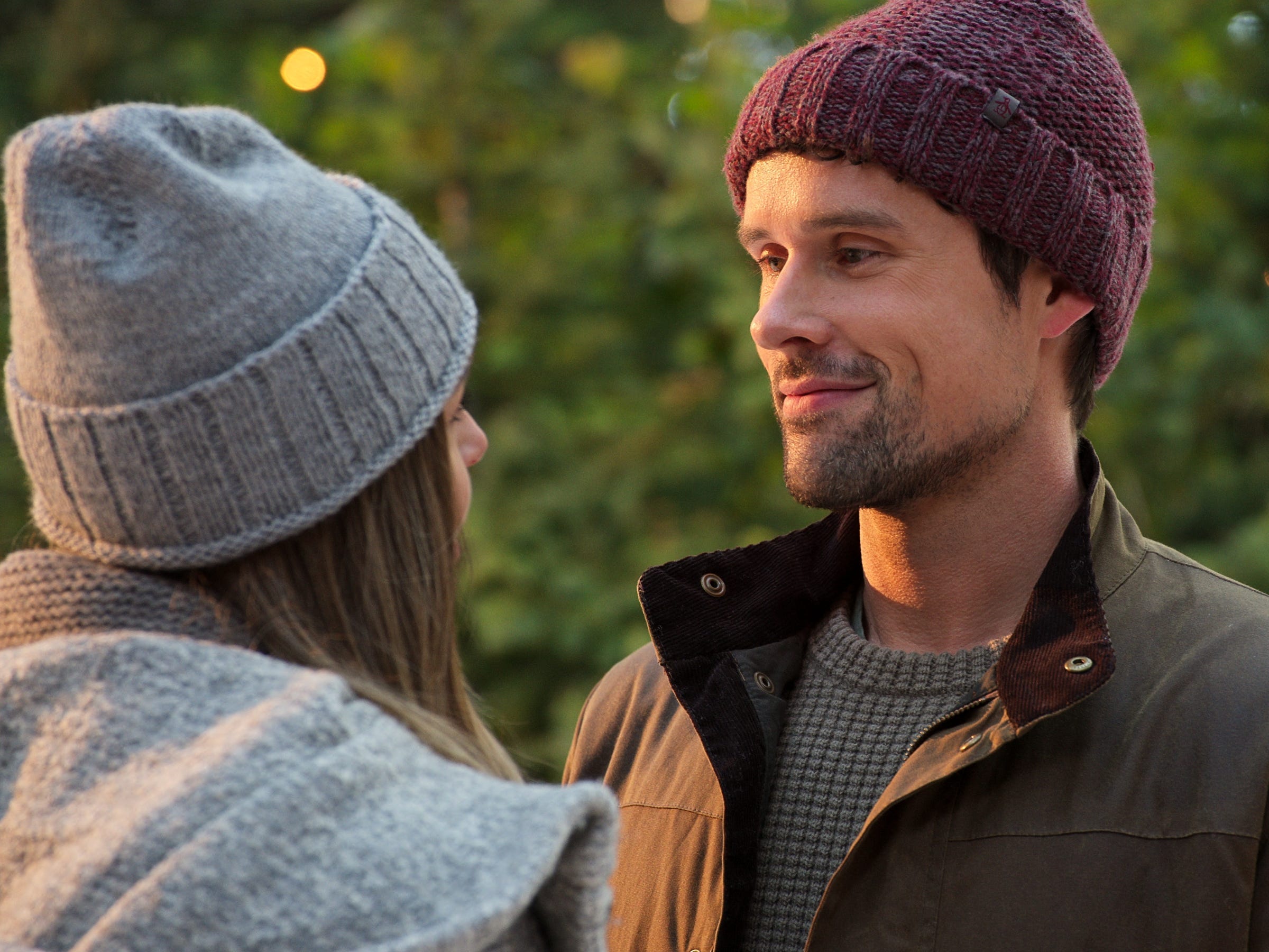 benjamin hollingsworth as brady in virgin river, wearing a red knit cap and smiling softly at a woman