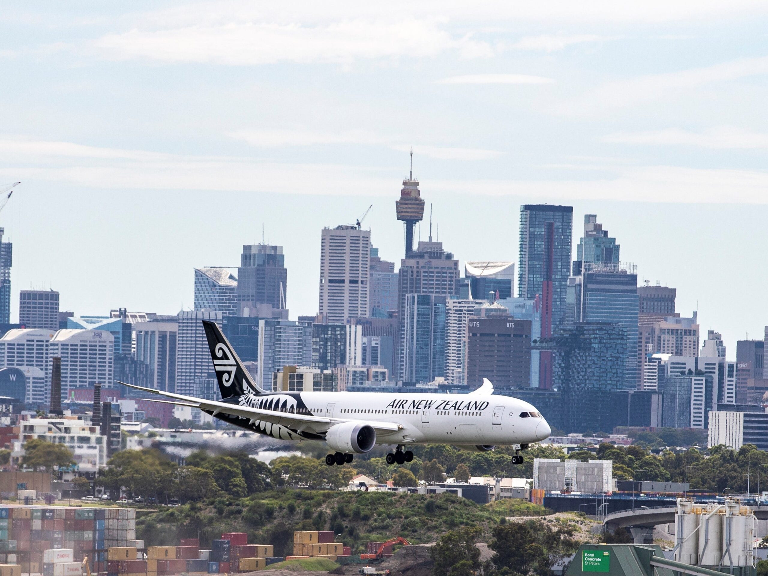 An Air New Zealand plane flies in front of the Sydney skyline