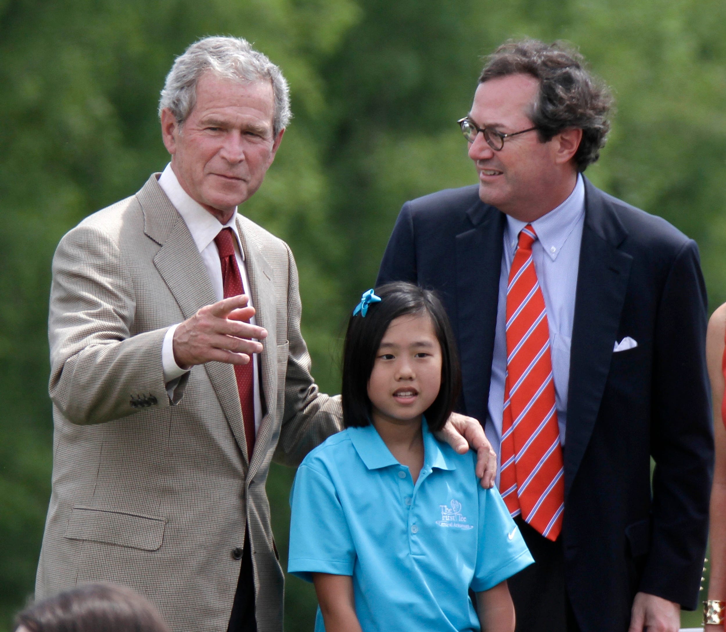 Former President George W. Bush, left, and Warren Stephens on the righ with Rebekah Walker in blue in the middle.