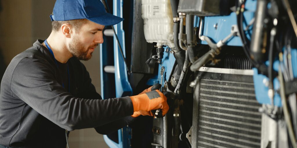 Man repareert motor van industrieel voertuig
