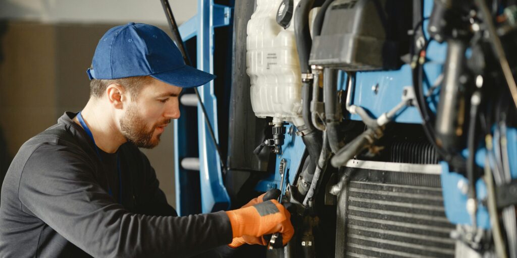 Man repareert motor van industrieel voertuig
