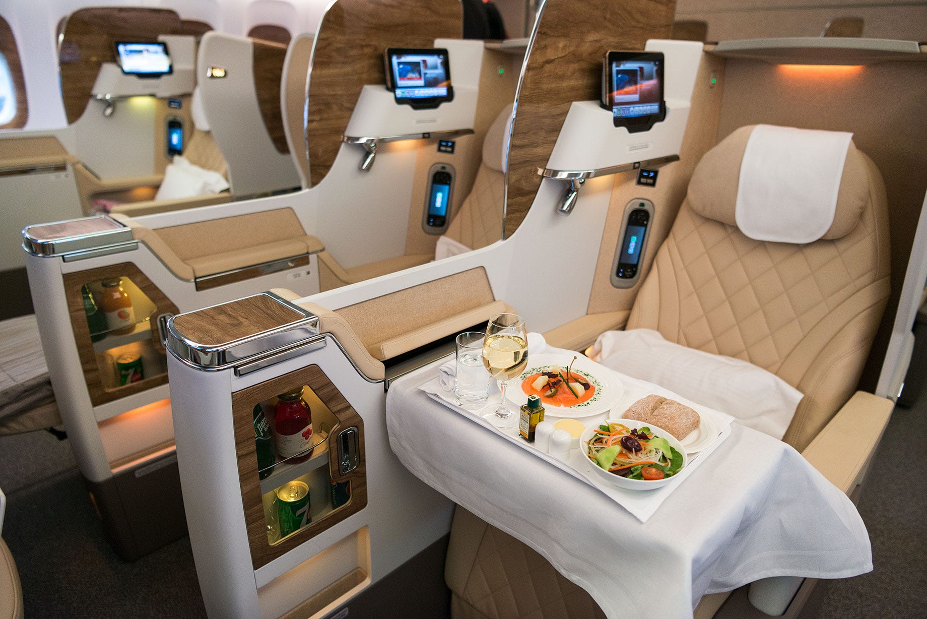 Emirates business class stoelen in de Boeing 777-300 ER met een maaltijd op het dienblad.