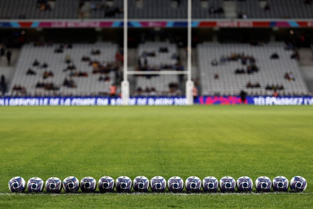 Balls lined up on a soccer field.