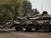 Oekraïense soldaten doorzoeken een verlaten Russische T-90 tank in Kharkiv.