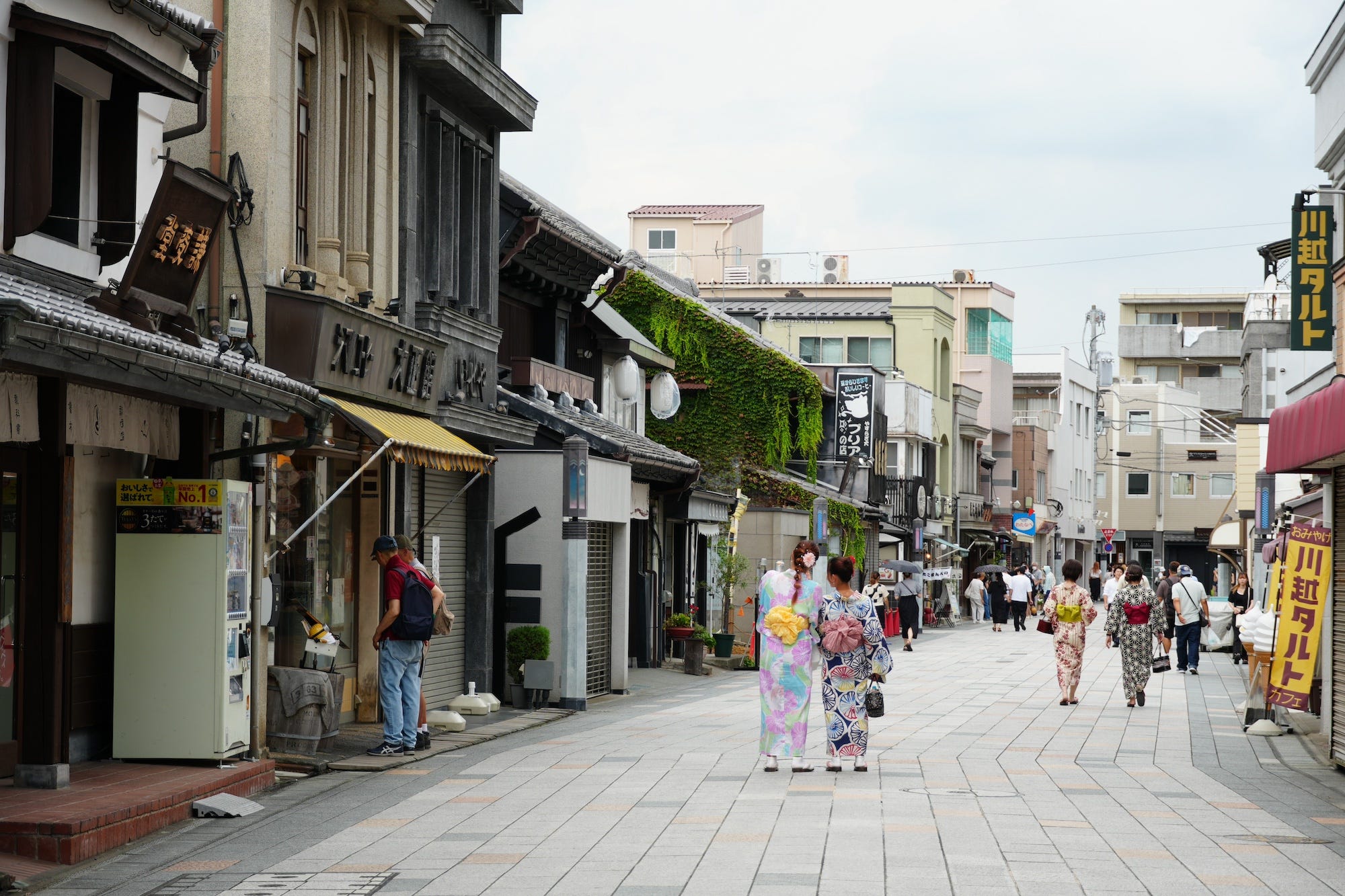 Twee toeristen in kimono's staan in het midden van Taisho Roman Street in Kawagoe.