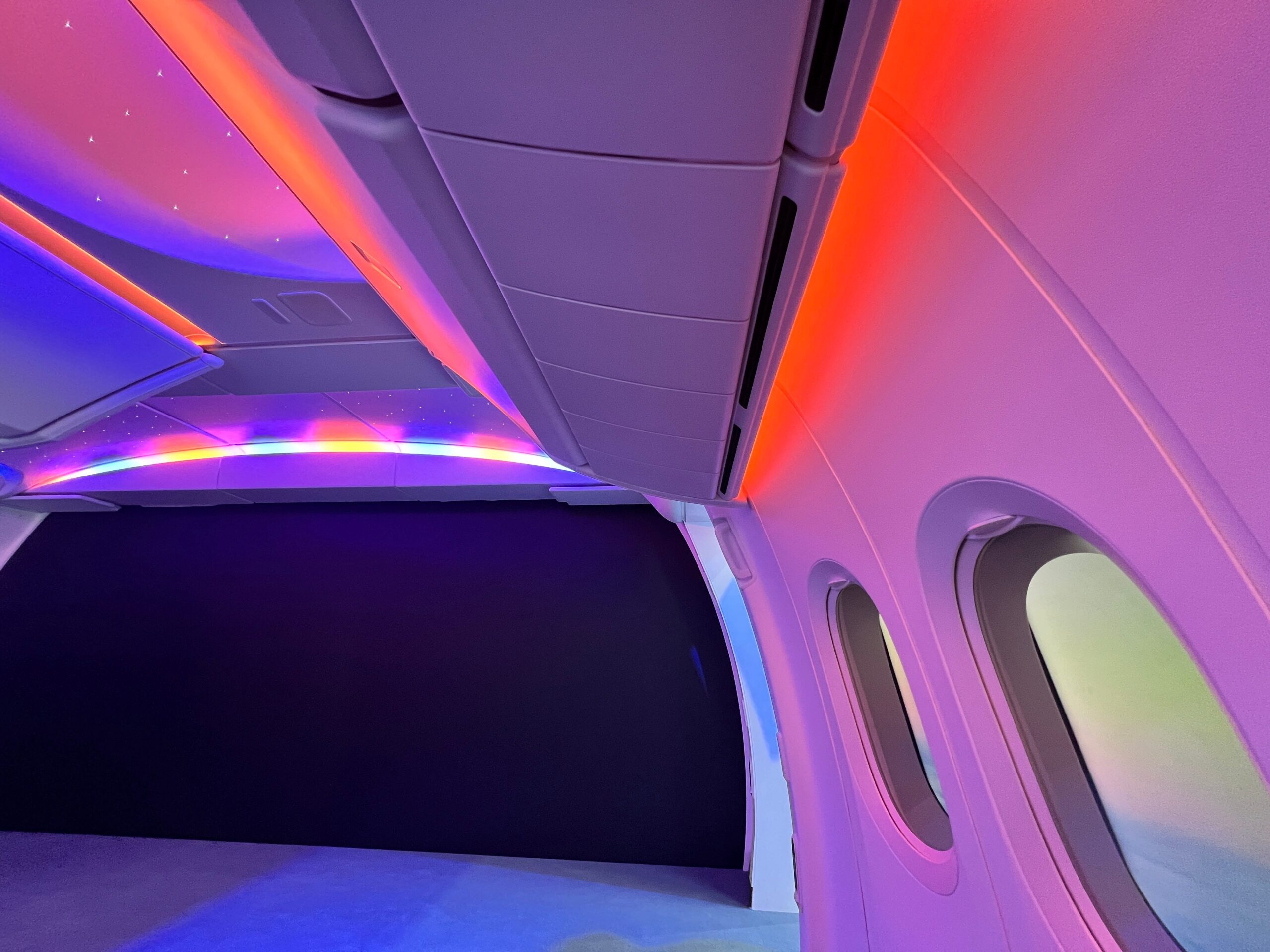 Rode en roze sfeerverlichting in een nagebouwde cabine van een Boeing 777X