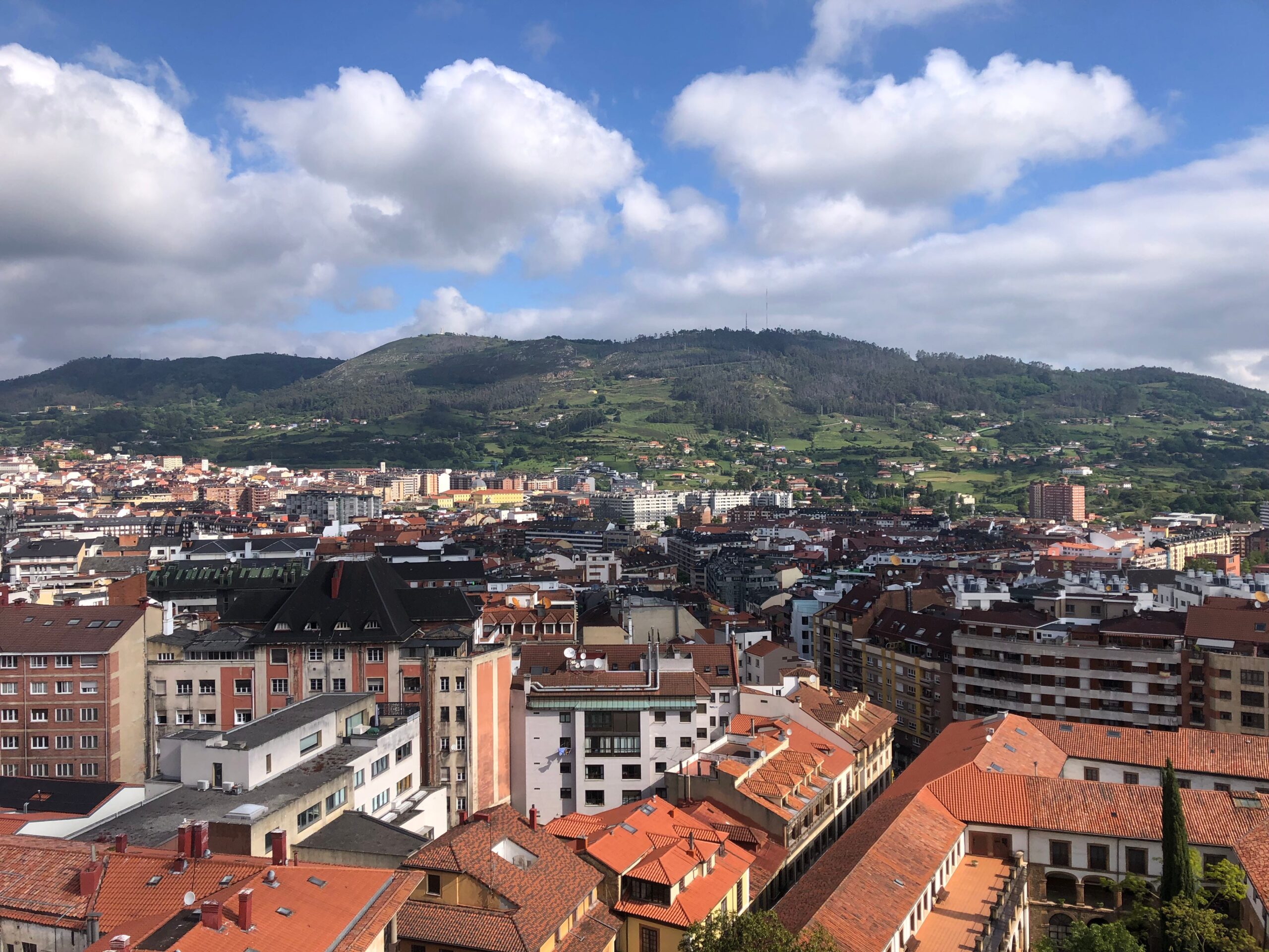 Bird's eye view of Asturias, Spain, featuring buildings and mountains.