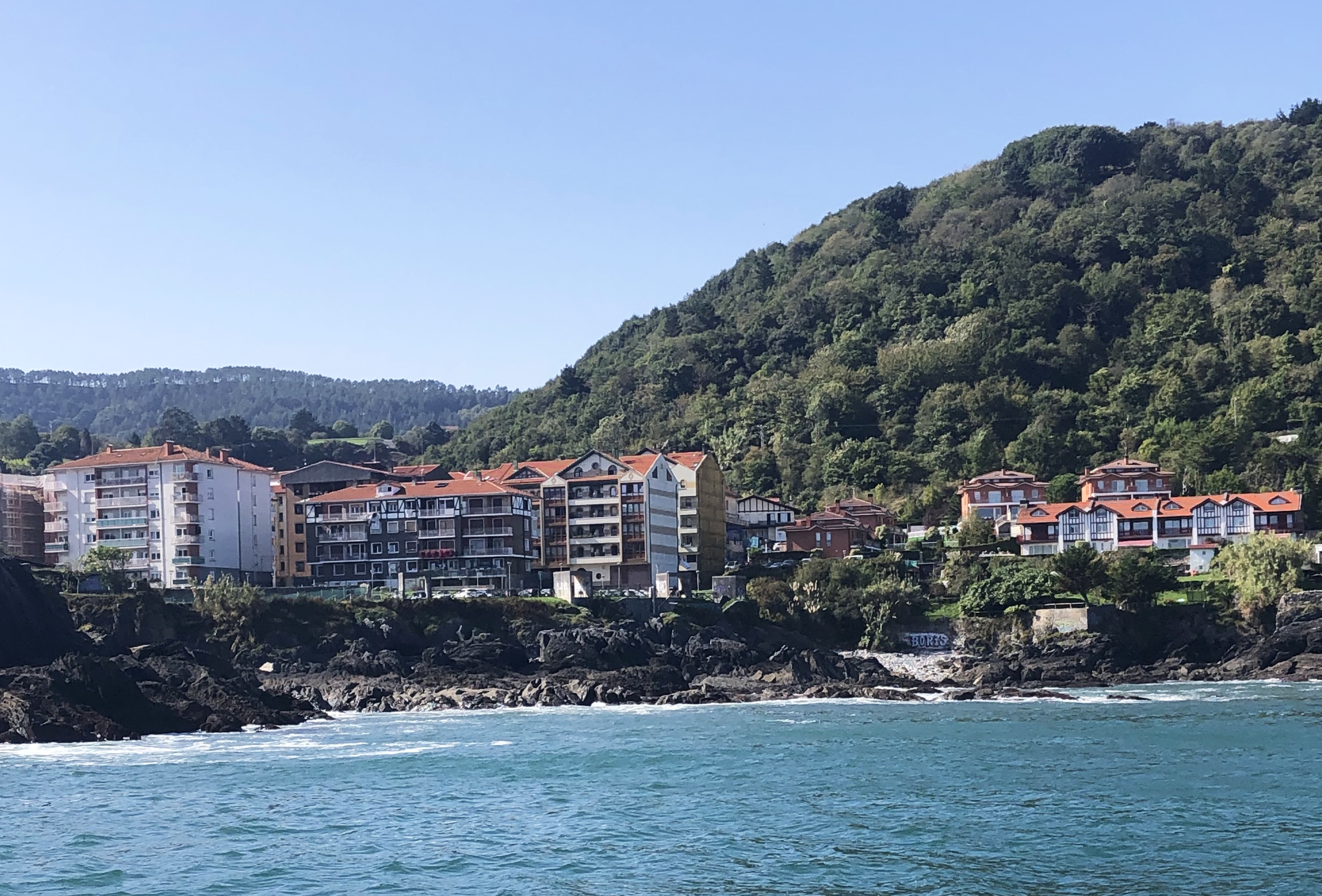 The Central Basque Coast in Spain featuring a view of the ocean and houses on the coast.