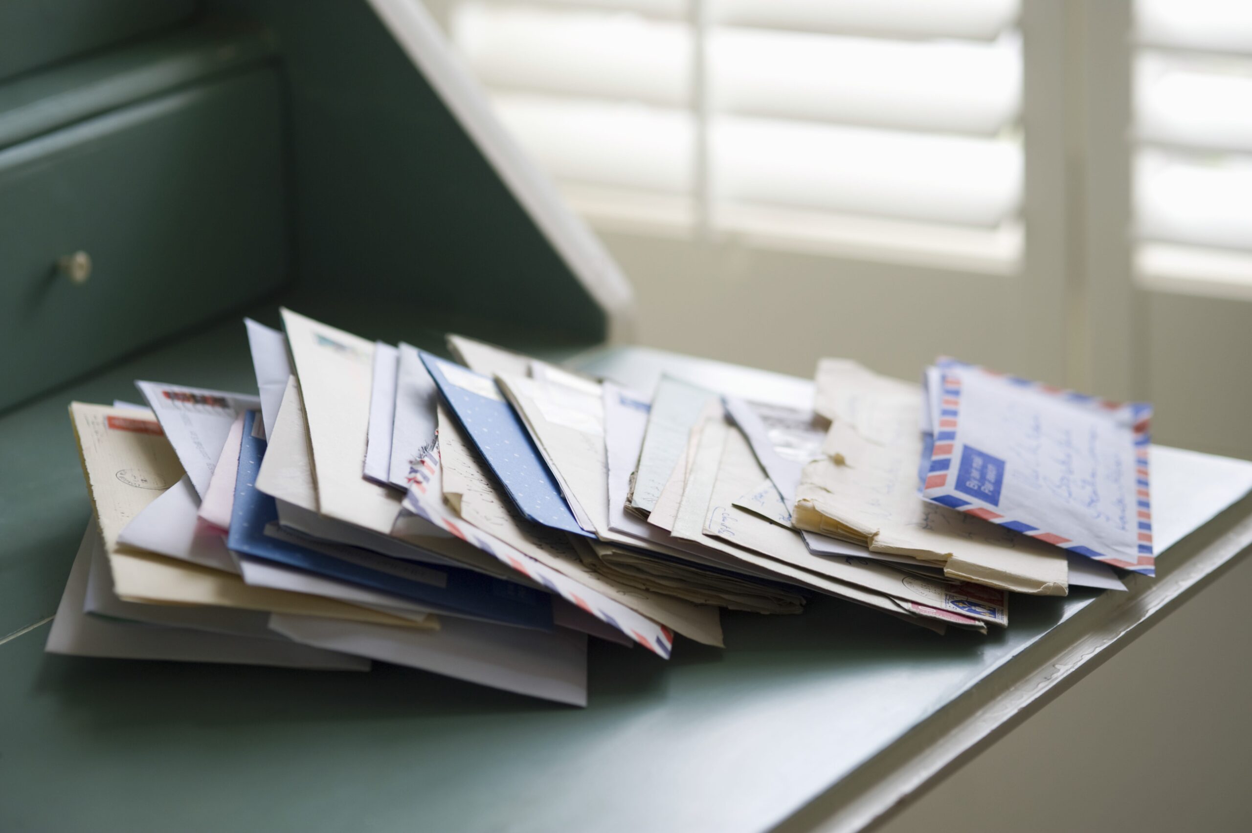 A stack of mail on a desk.