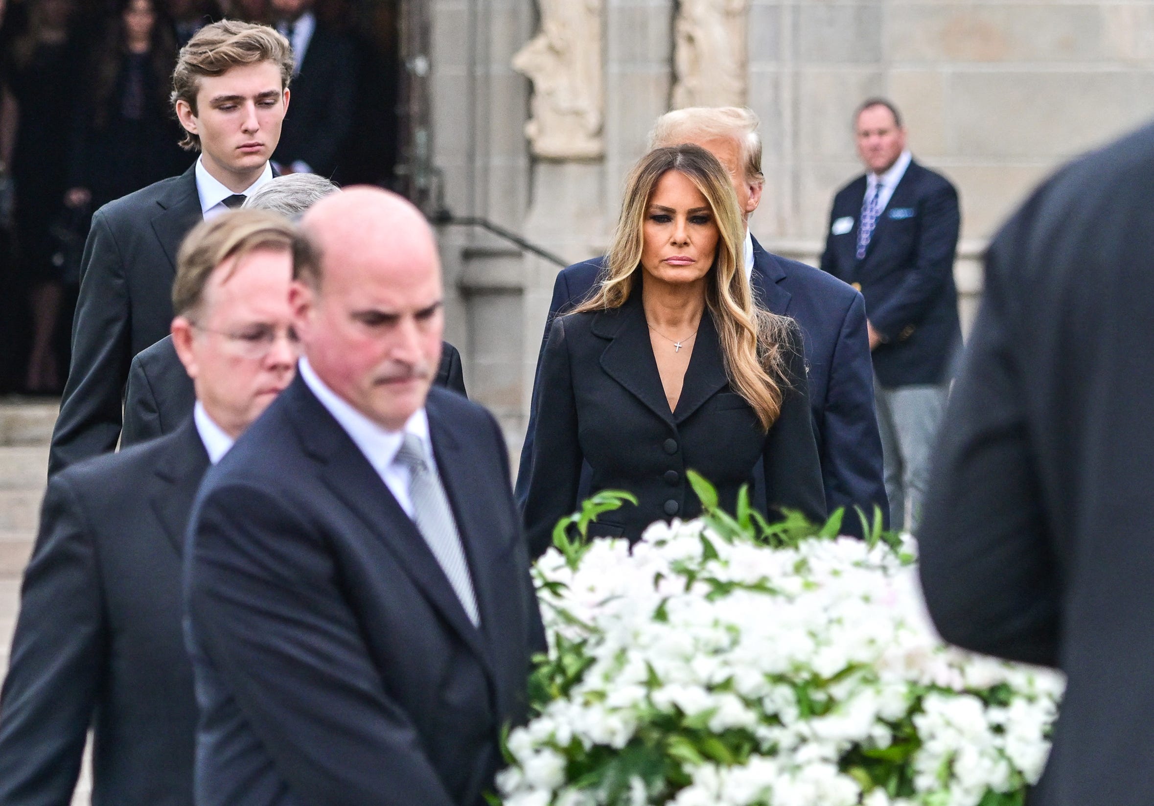 Barron Trump, Melania Trump, and Donald Trump at funeral